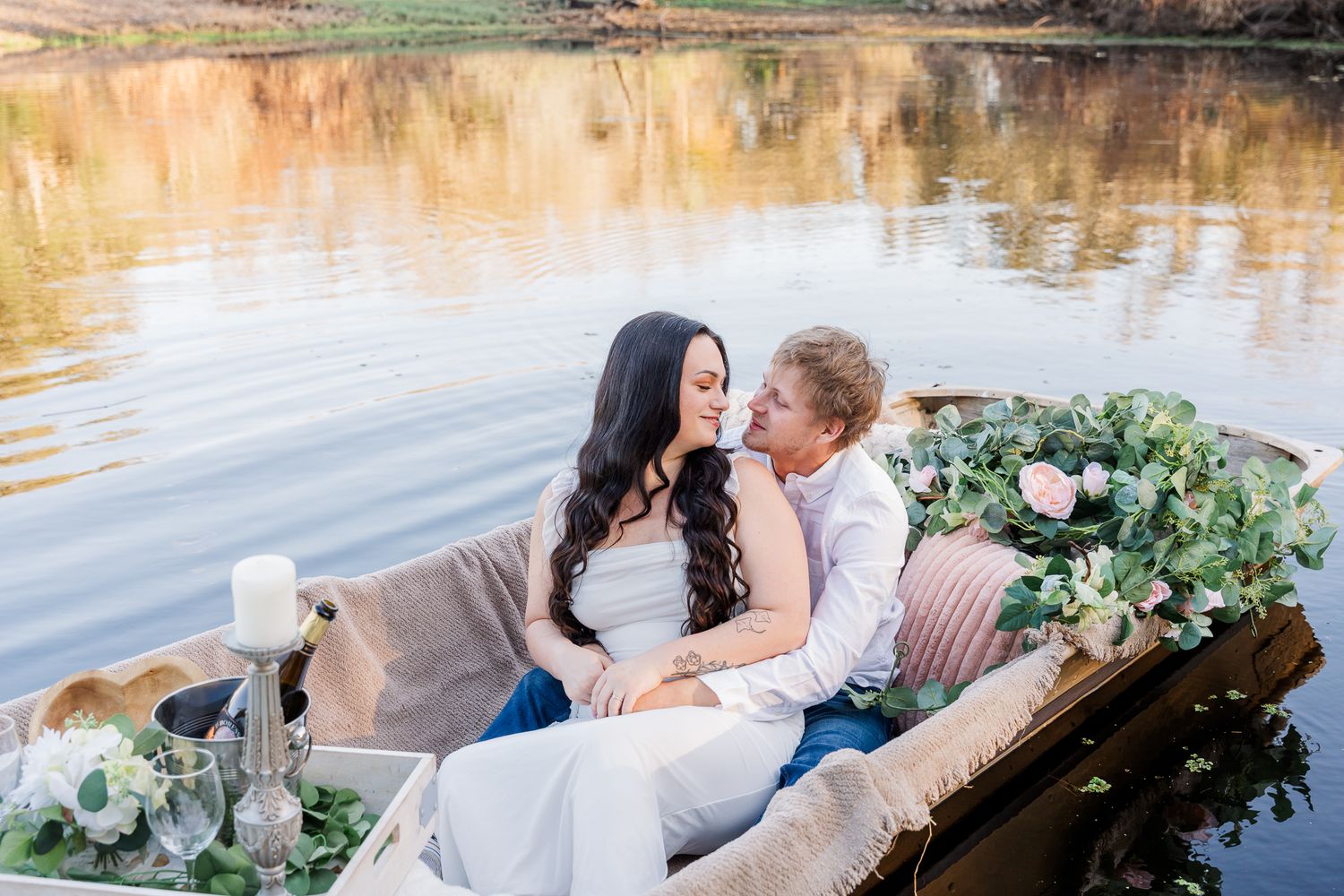 Romantic couple on a lake with lush greenery and floral arrangements during their engagement session. Central Florida Wedding Photographer