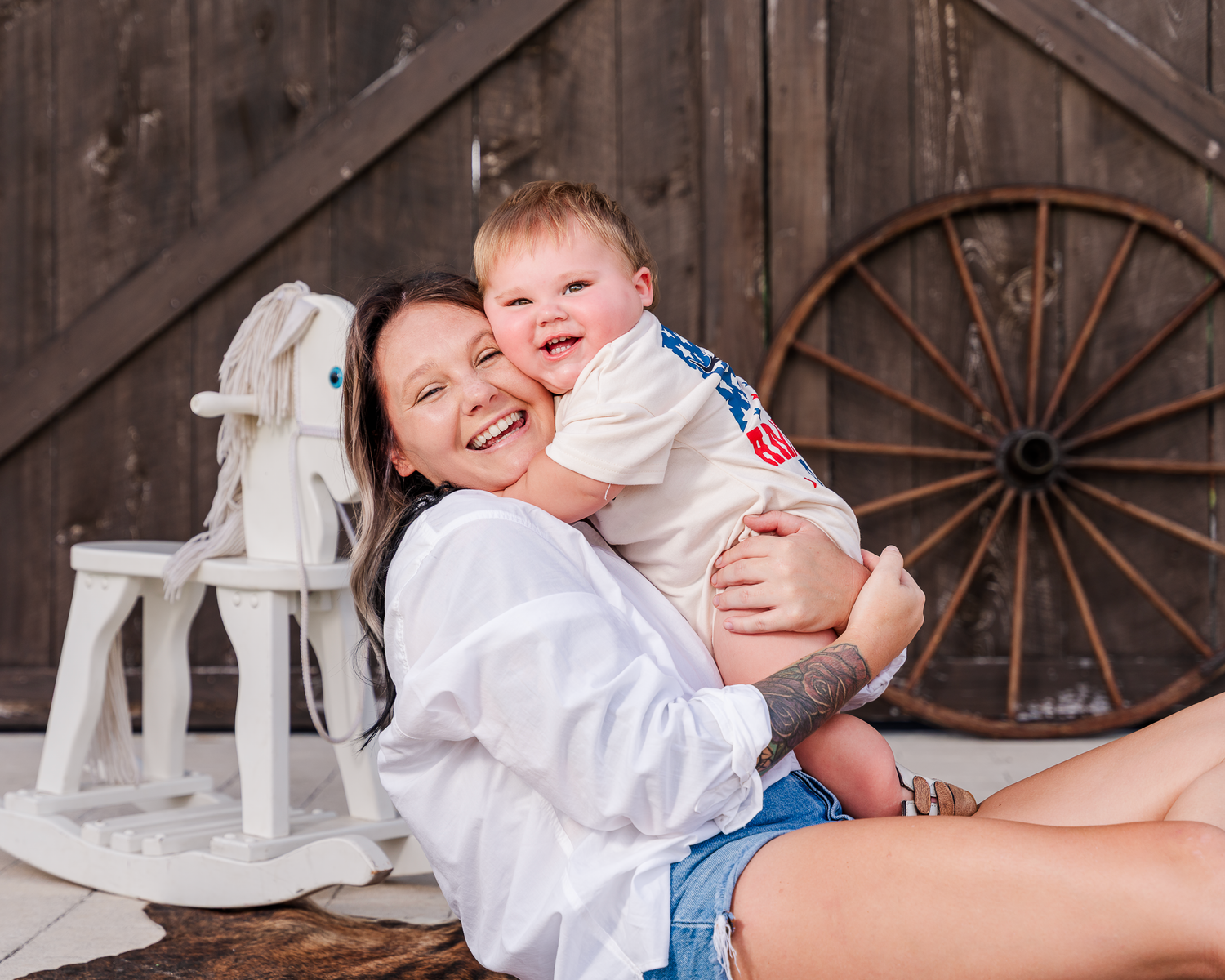 A heartwarming family photo session featuring playful interactions against a rustic barn wood background.
