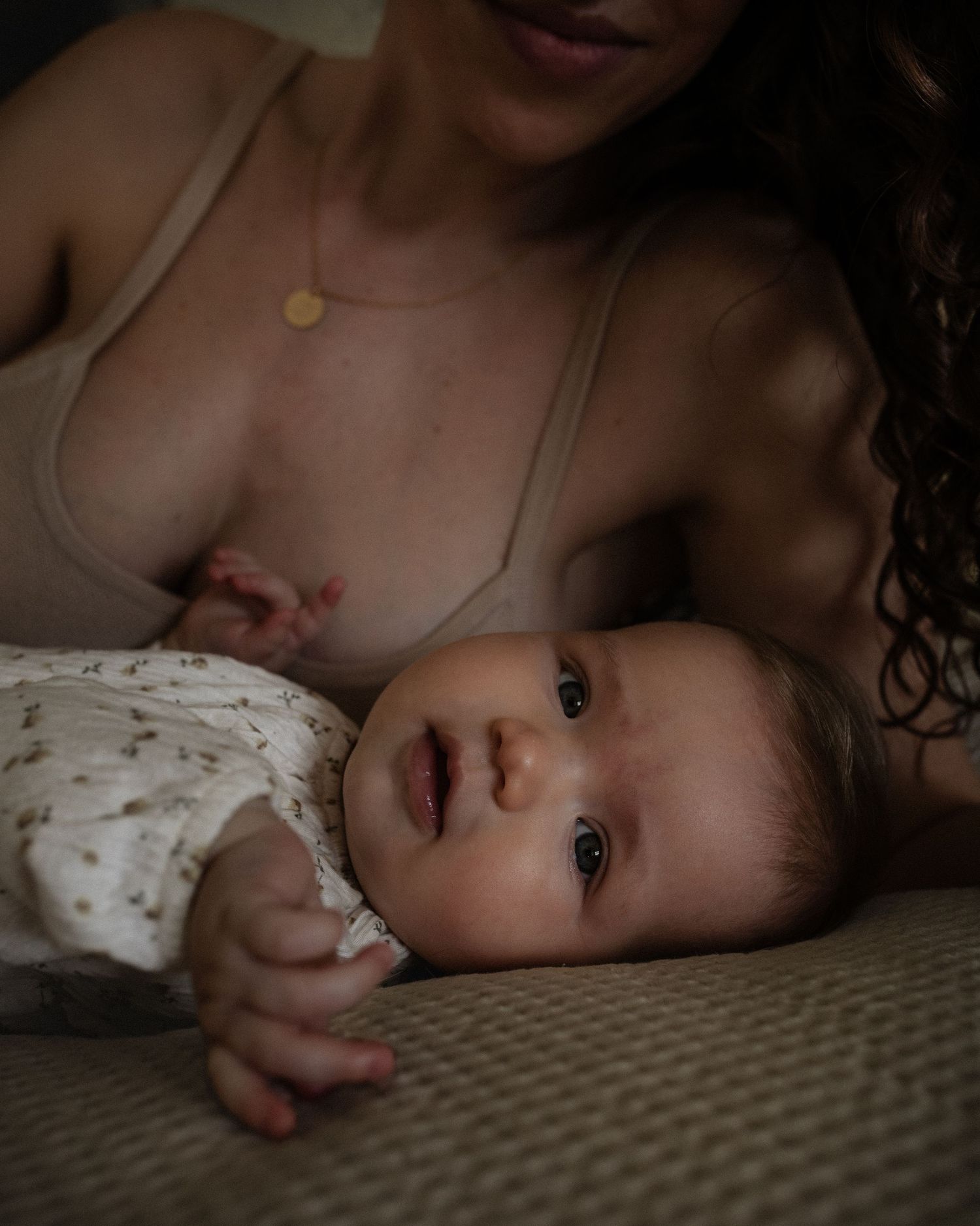 Close-up of a baby with her mother laying down