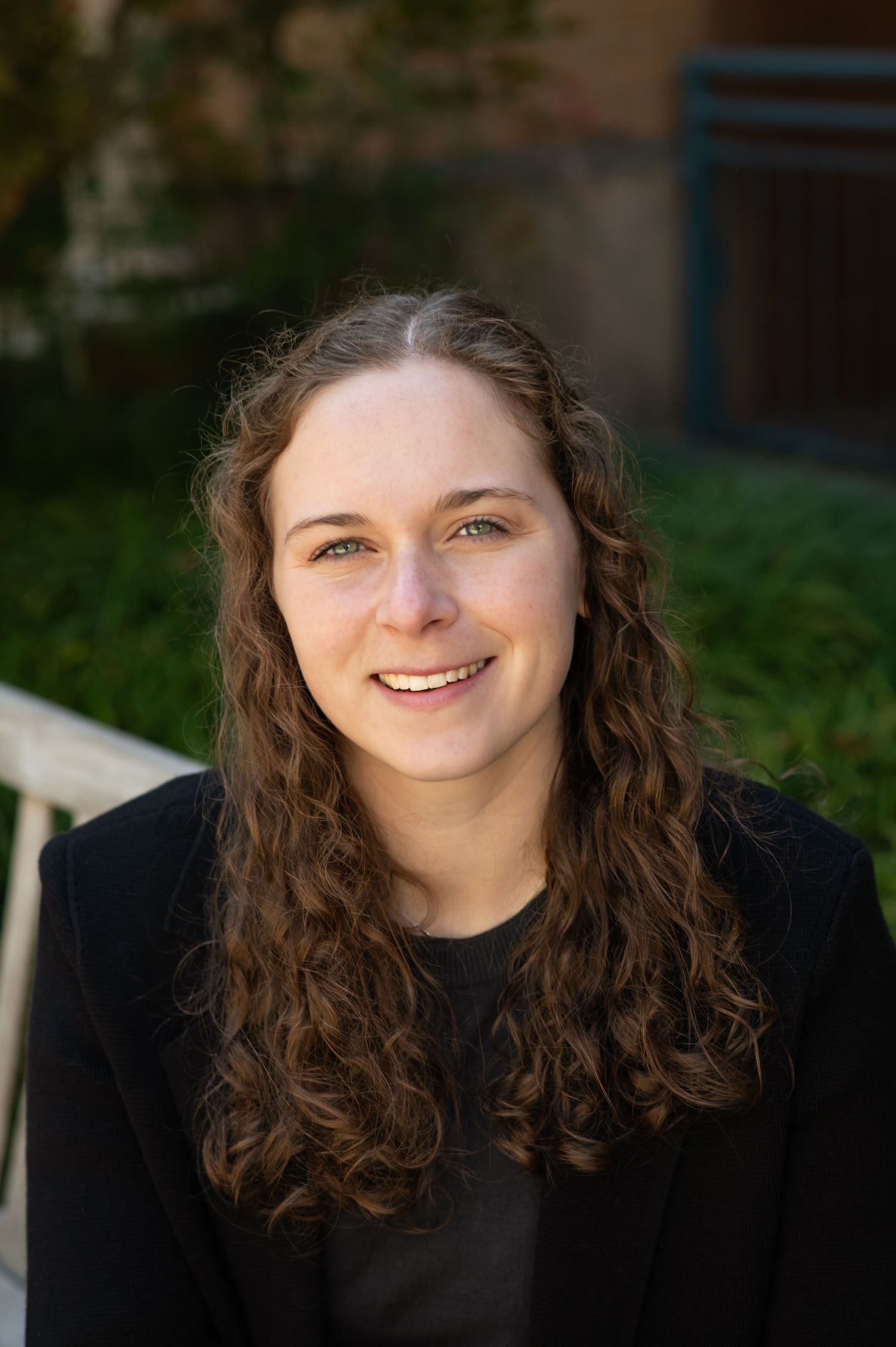 A series of portrait photos showing a person with curly brown hair and a black shirt against a dark background.