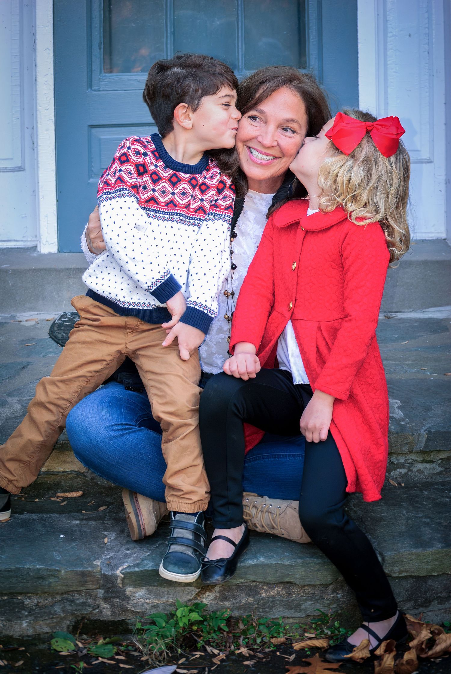 A sequence of four candid photos showing affectionate family moments on stone steps with autumn leaves scattered below.