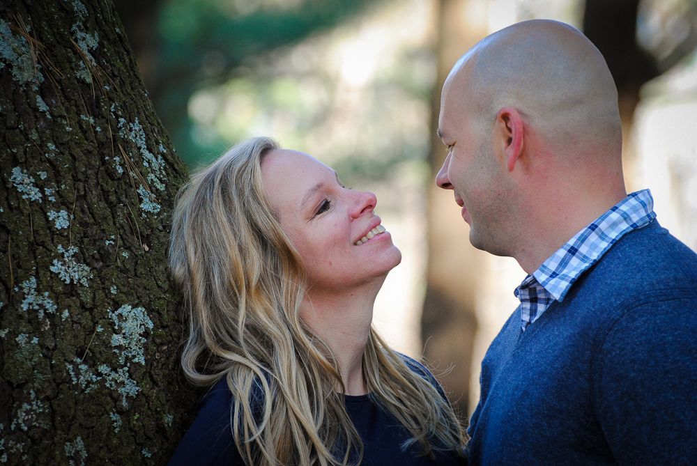 Romantic couple shares tender moments in a natural outdoor setting during engagement photo session.