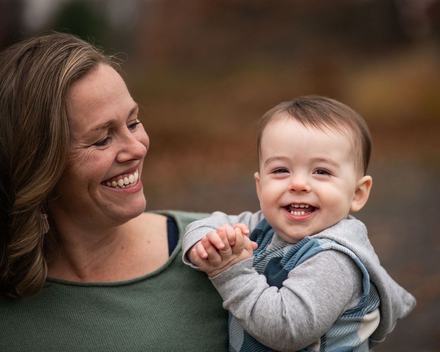 A heartwarming sequence of candid moments between a parent and child playing together outdoors on an autumn day.