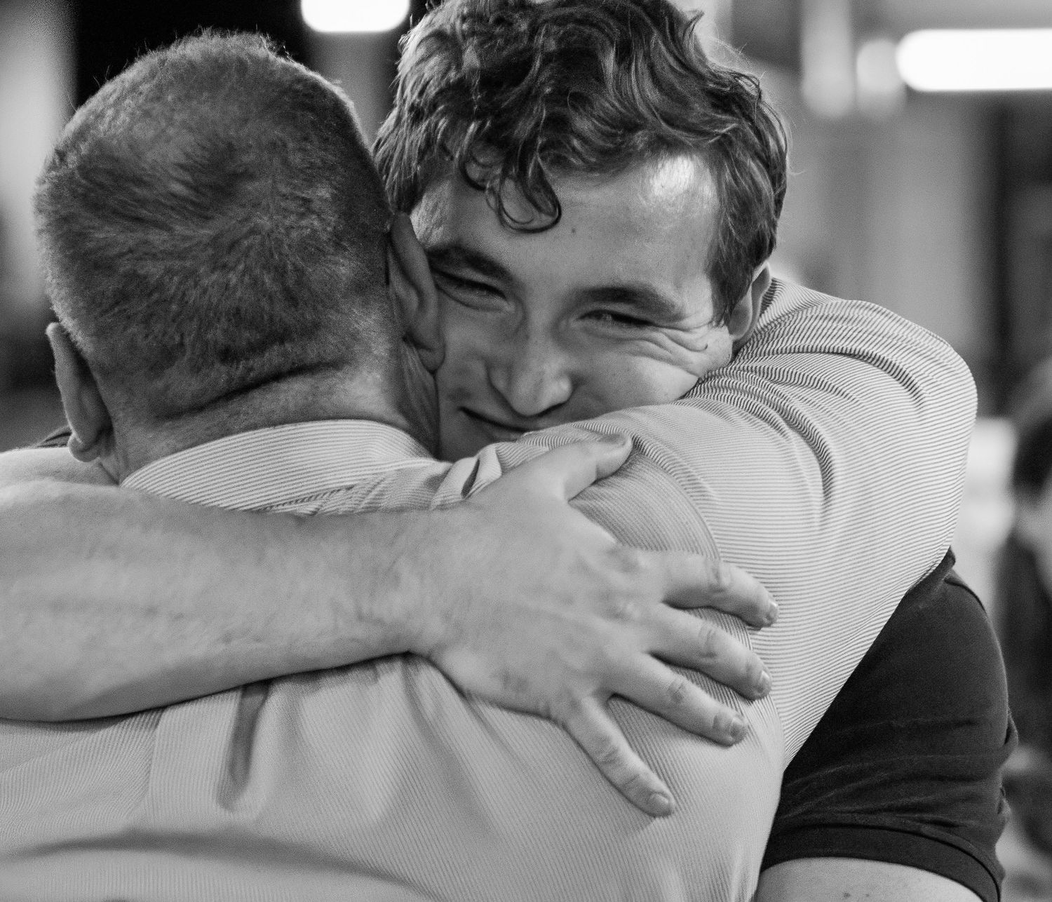 A series of black and white photos showing affectionate embraces between people in a candid sequence.