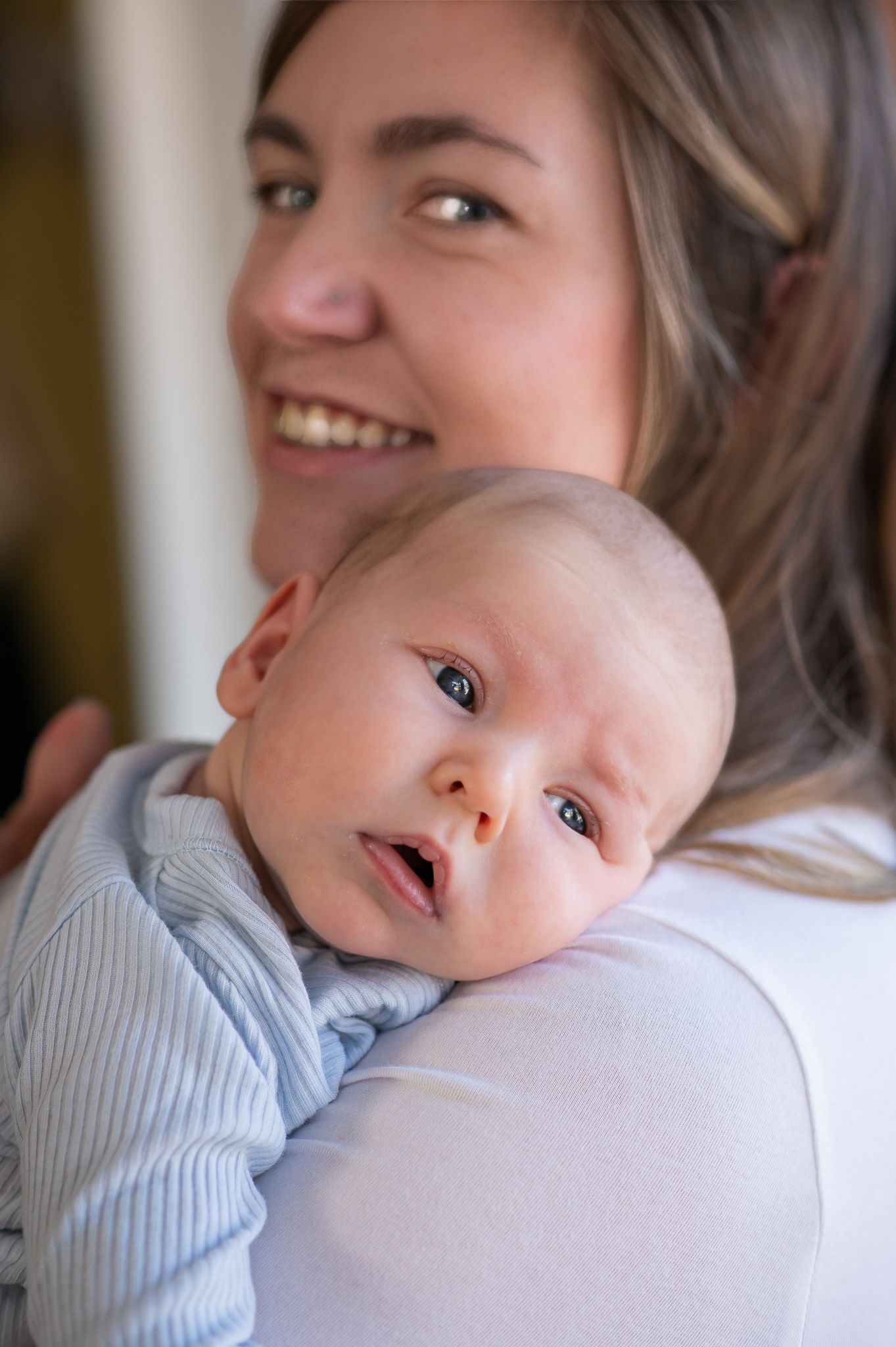 A sweet moment captured in a series of photos showing a baby in a light blue outfit being held and cuddled.
