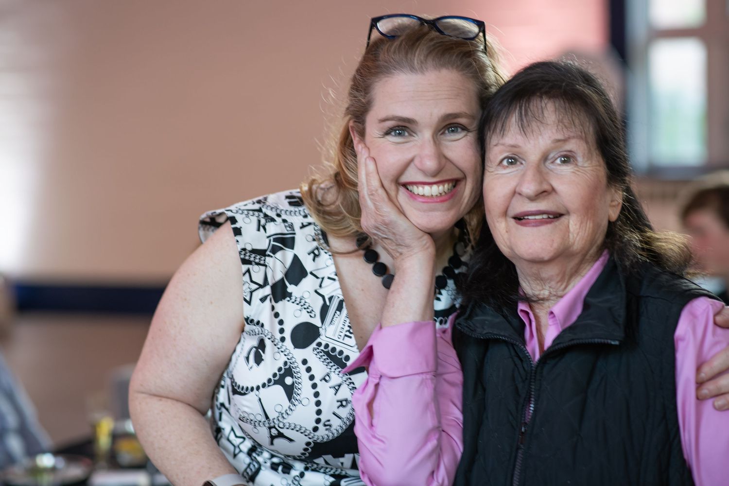 A series of candid moments showing two people in black and white and pink clothing sharing joyful interactions.