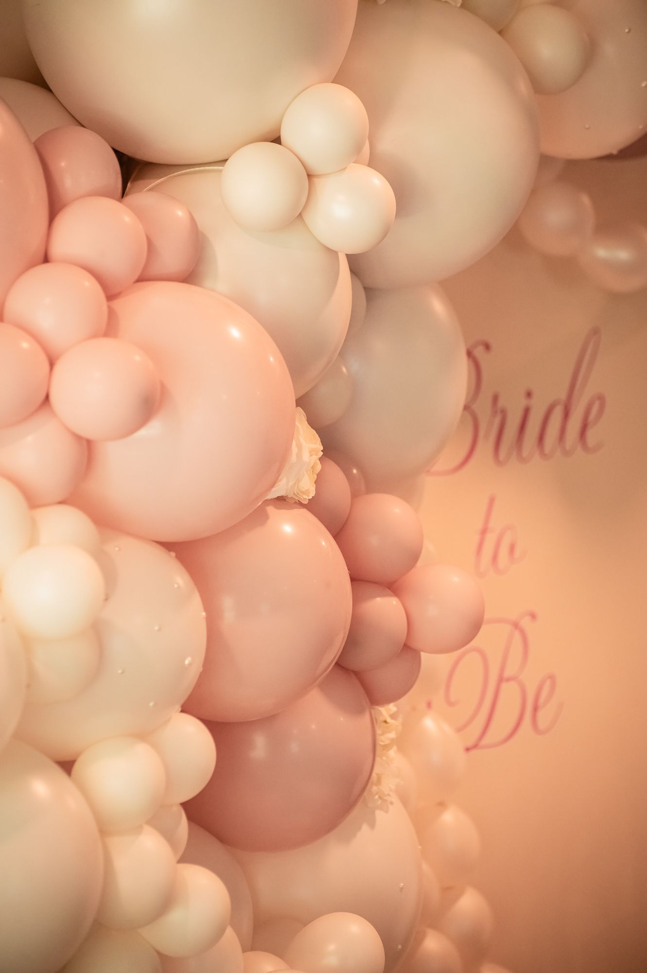 Elegant bridal shower balloon wall featuring soft pink and cream balloons with Bride to Be text backdrop.