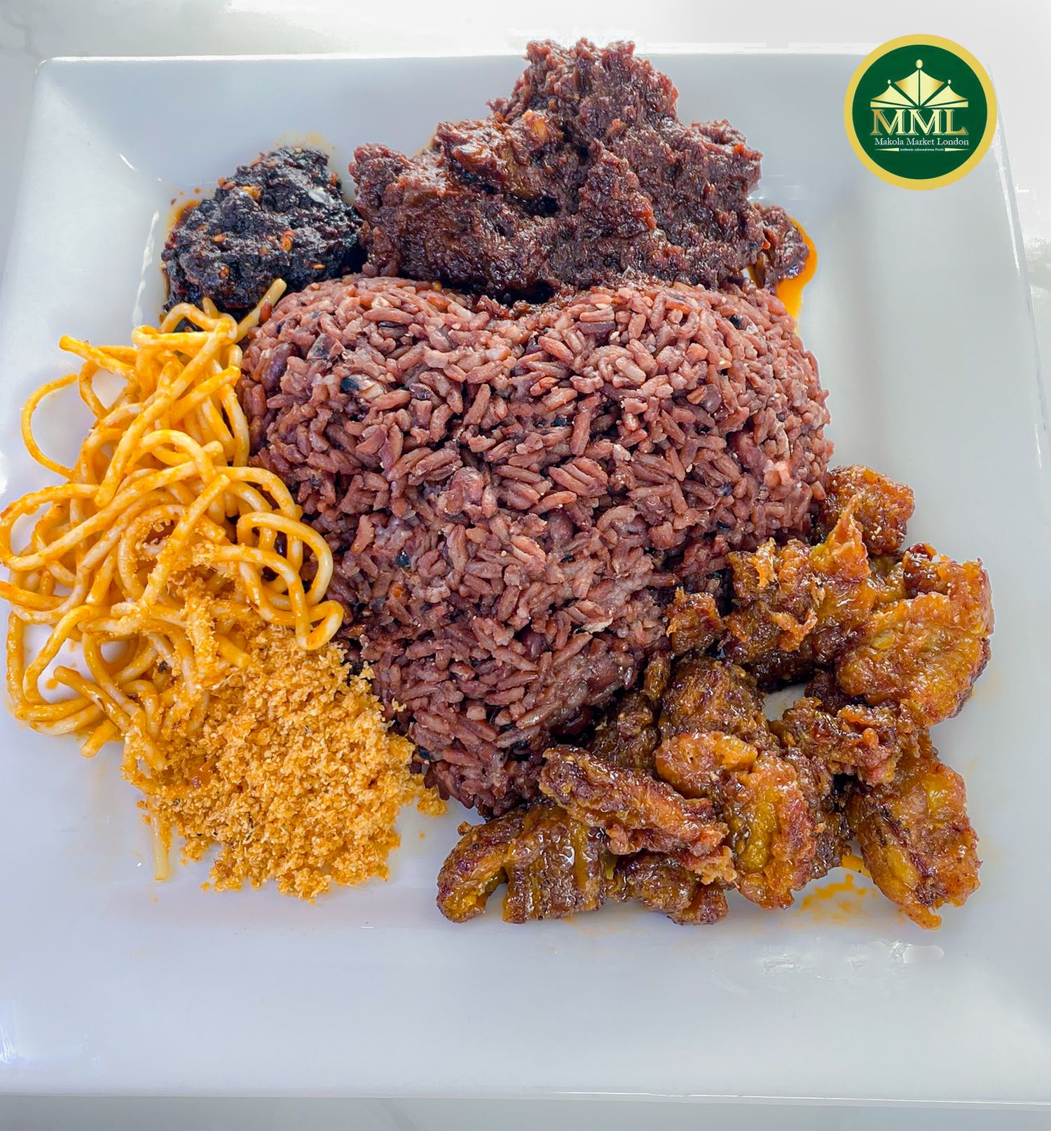 A plate of purple rice served with crispy shredded carrots, ground spices, and cooked seasoned meat.