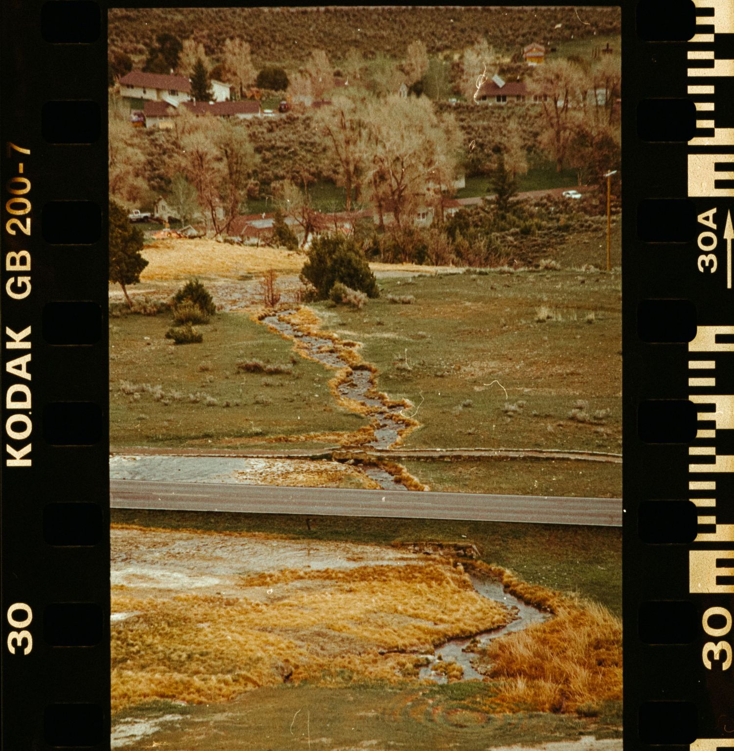Aerial view of a winding stream through a colorful autumn valley captured on Kodak film.