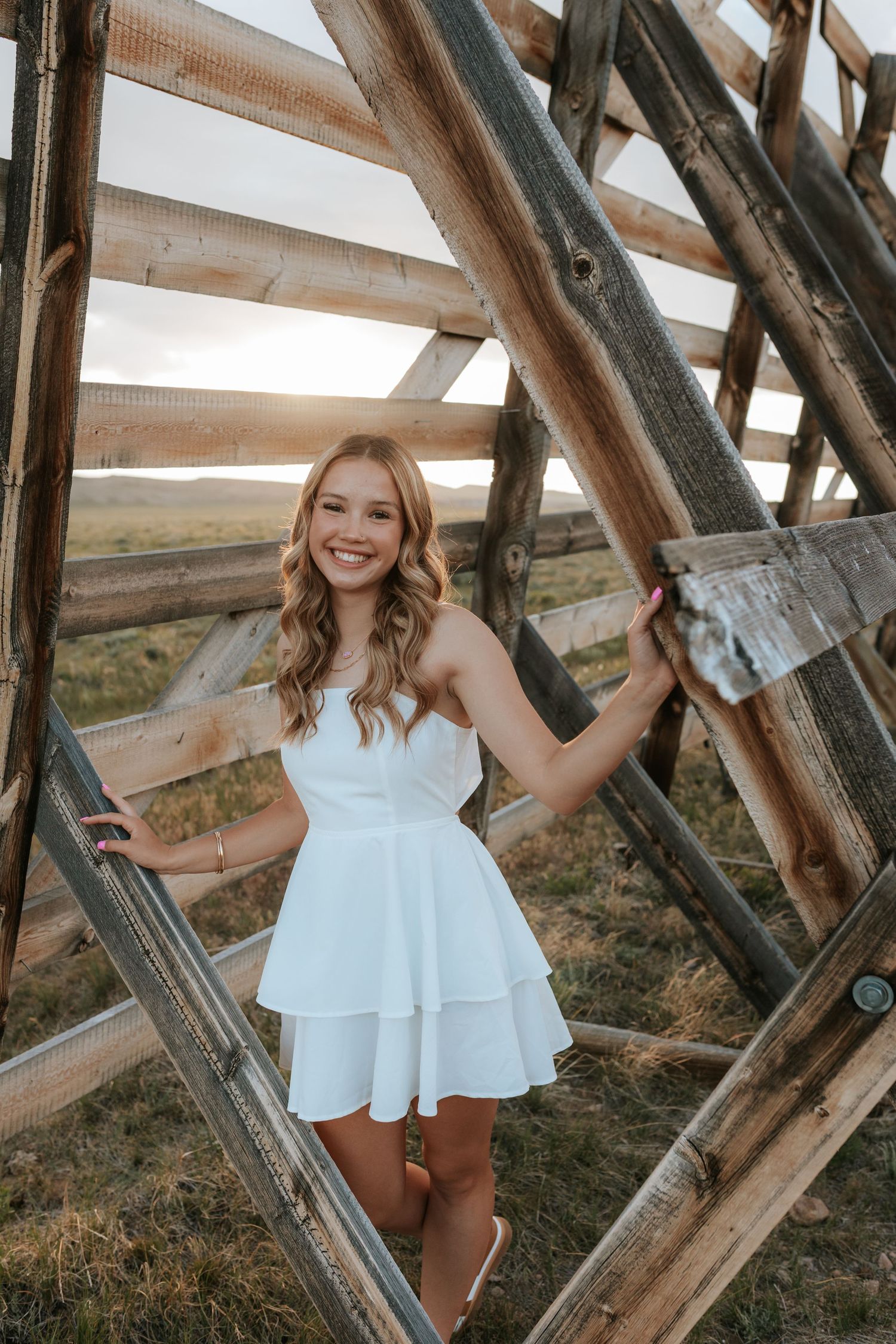 Portrait between wooden beams of rustic structure in countryside setting.