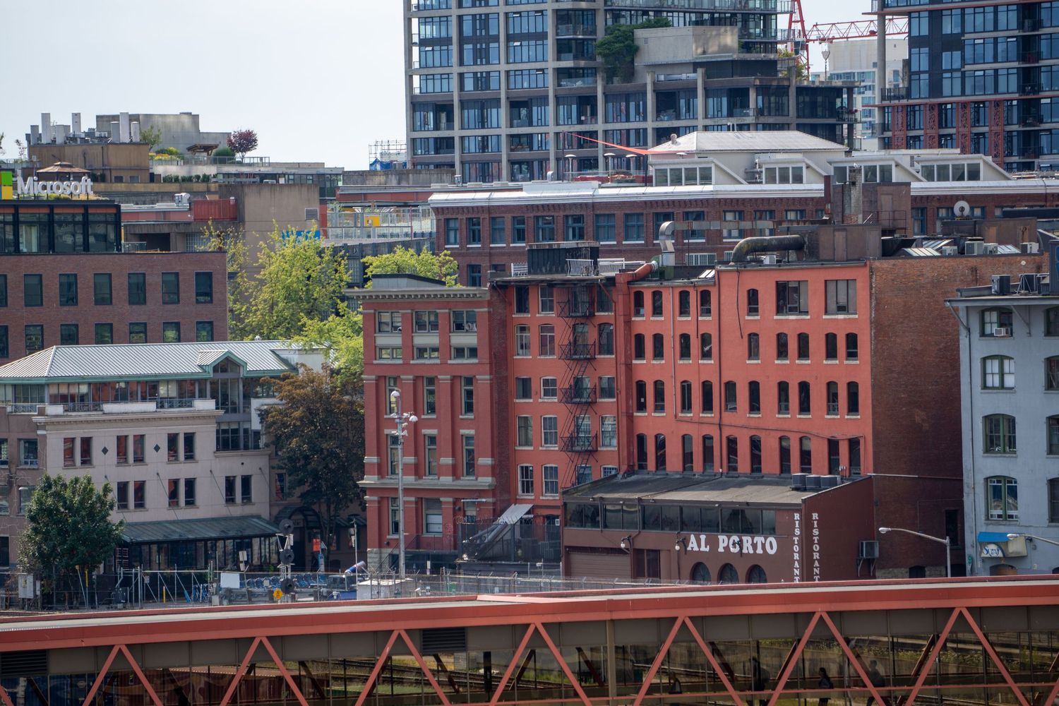 Historic brick buildings and modern architecture along city waterfront.