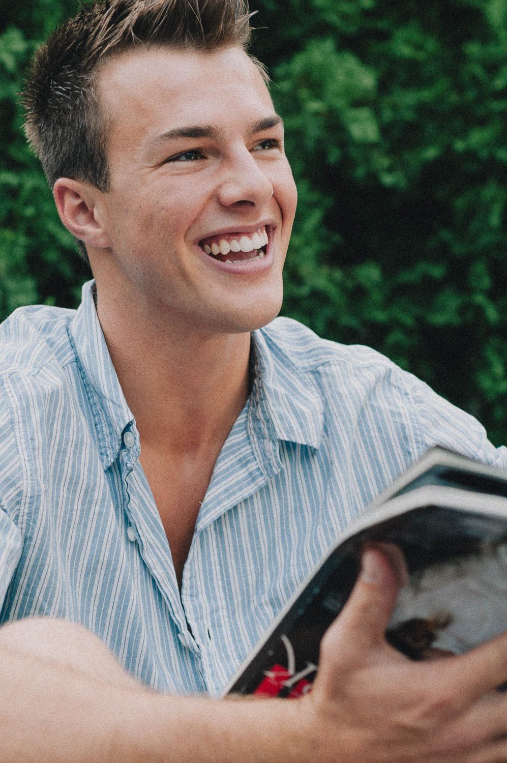 Lifestyle portrait of young man outside reading a magazine