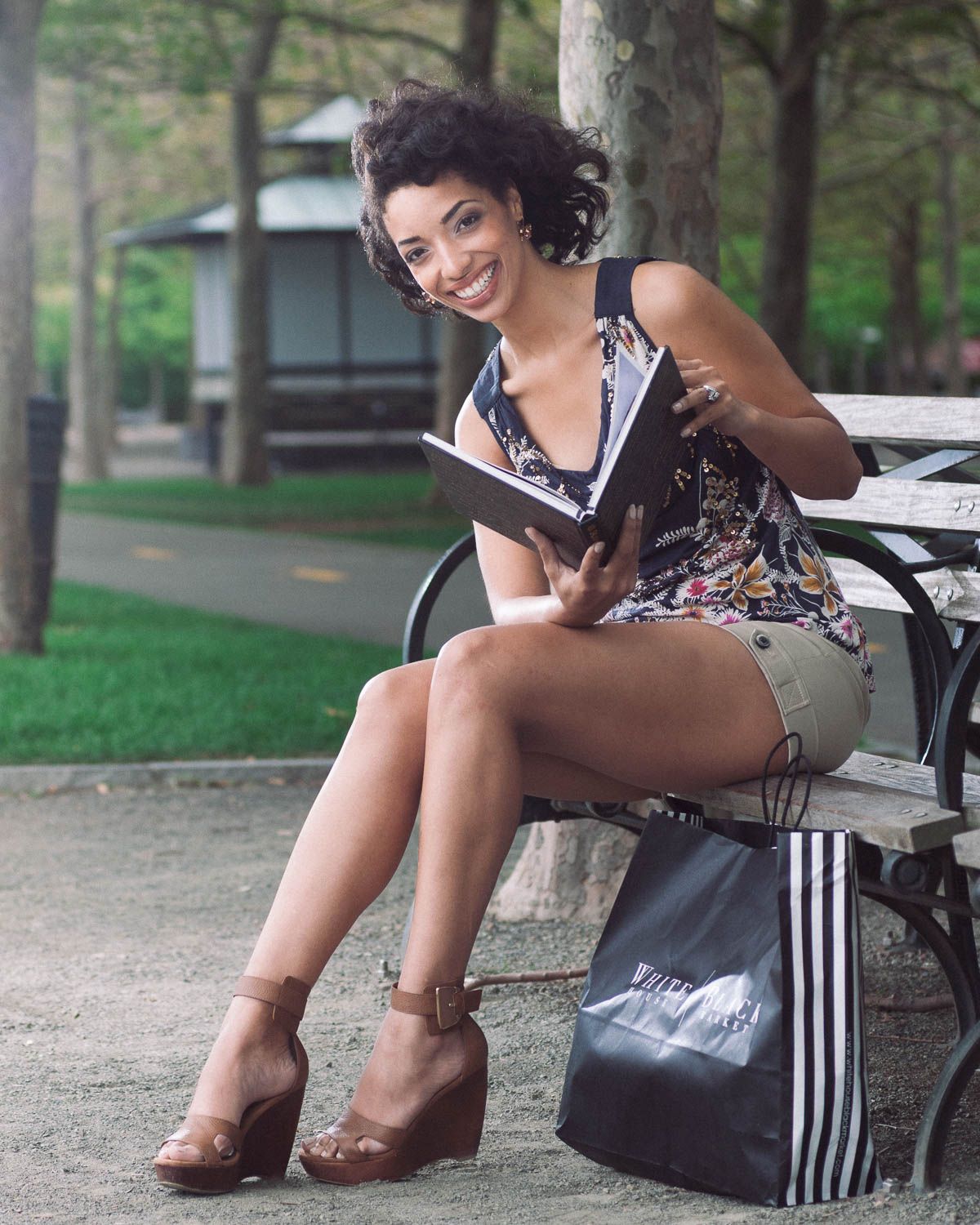 Fashion branding photo for clothing with a young woman outside sitting on a park bench
