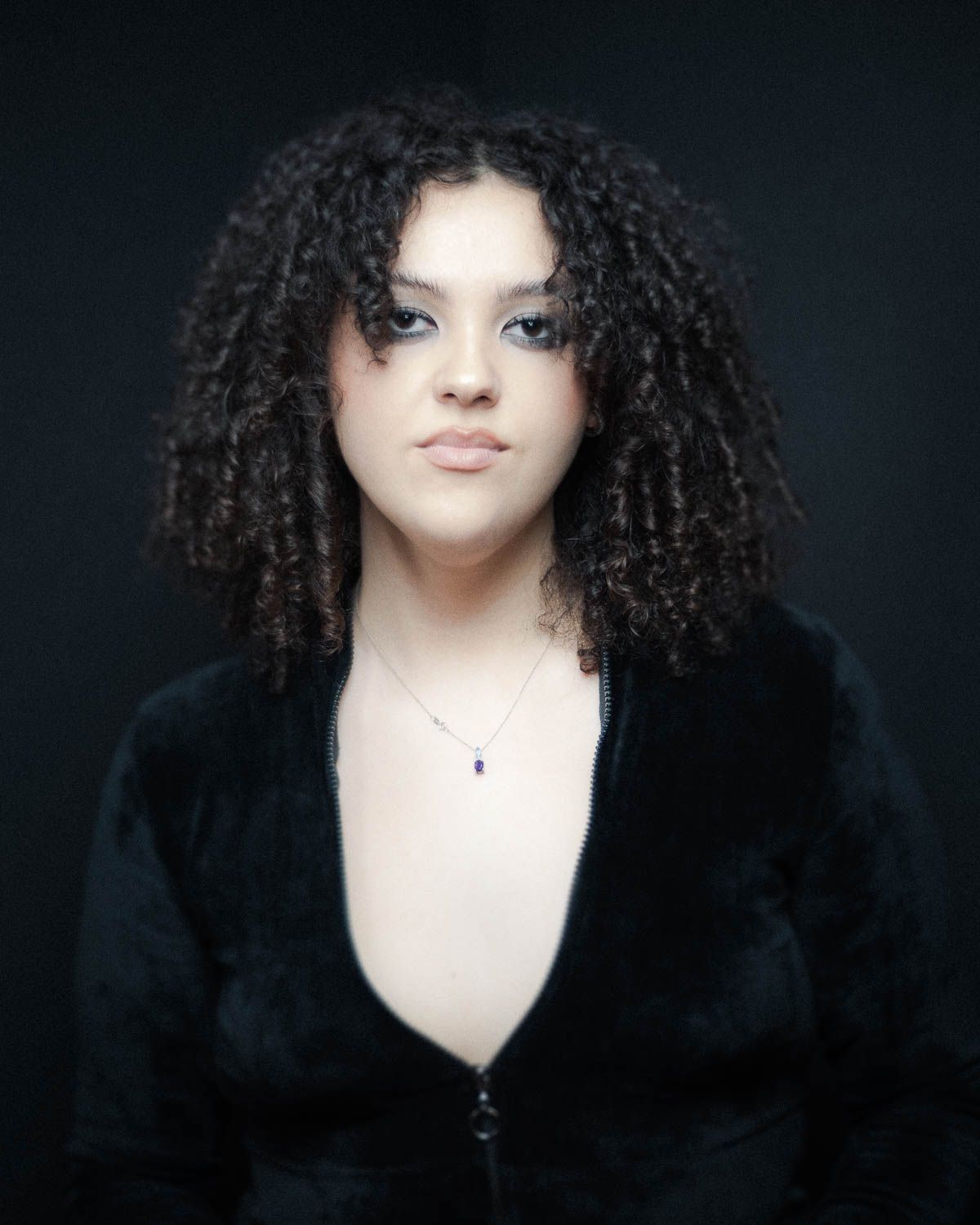 Portrait of young woman with dark hair in studio