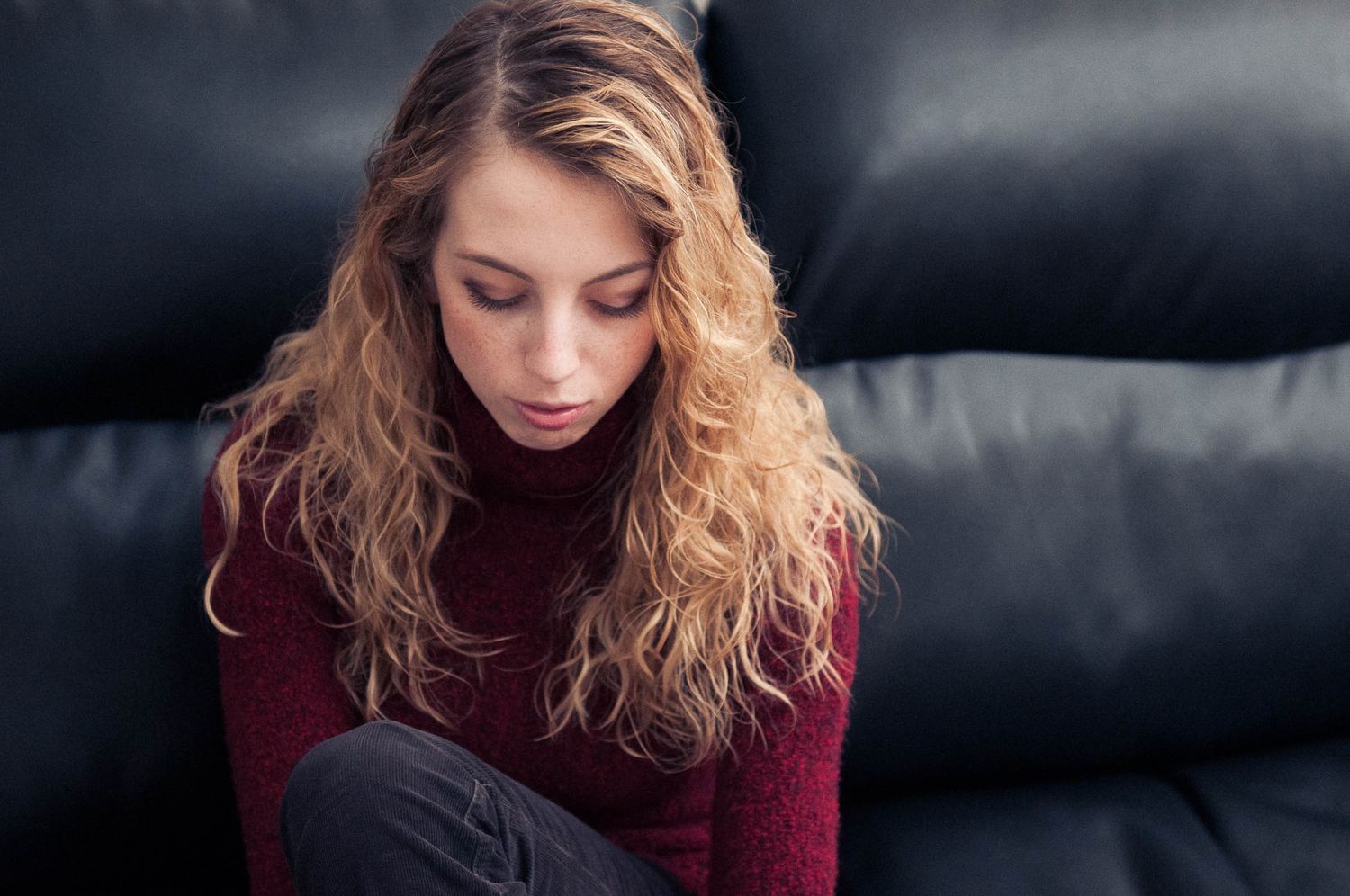 Creative portrait of woman with light hair sitting on a couch