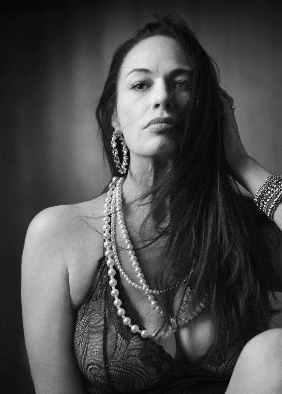 Creative and moody black and white portrait of young woman with dark hair in studio