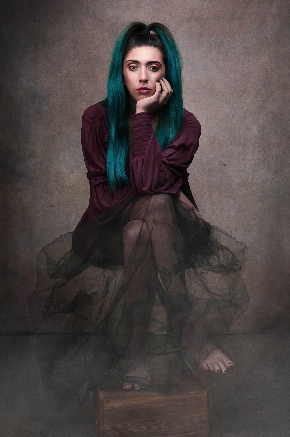 Stylized creative portrait of young woman with dark hair in studio