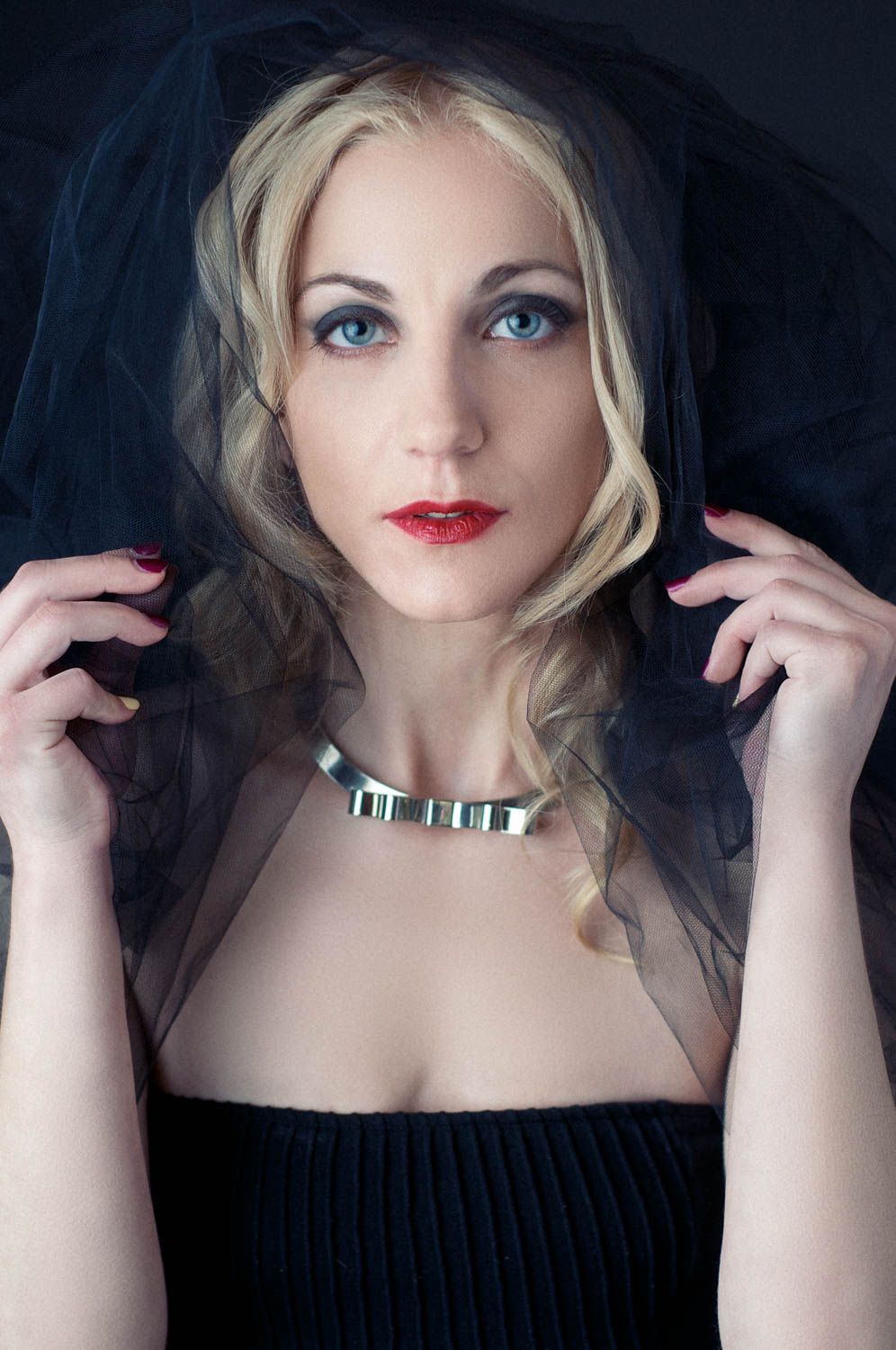 Creative portrait of young woman with light hair in studio