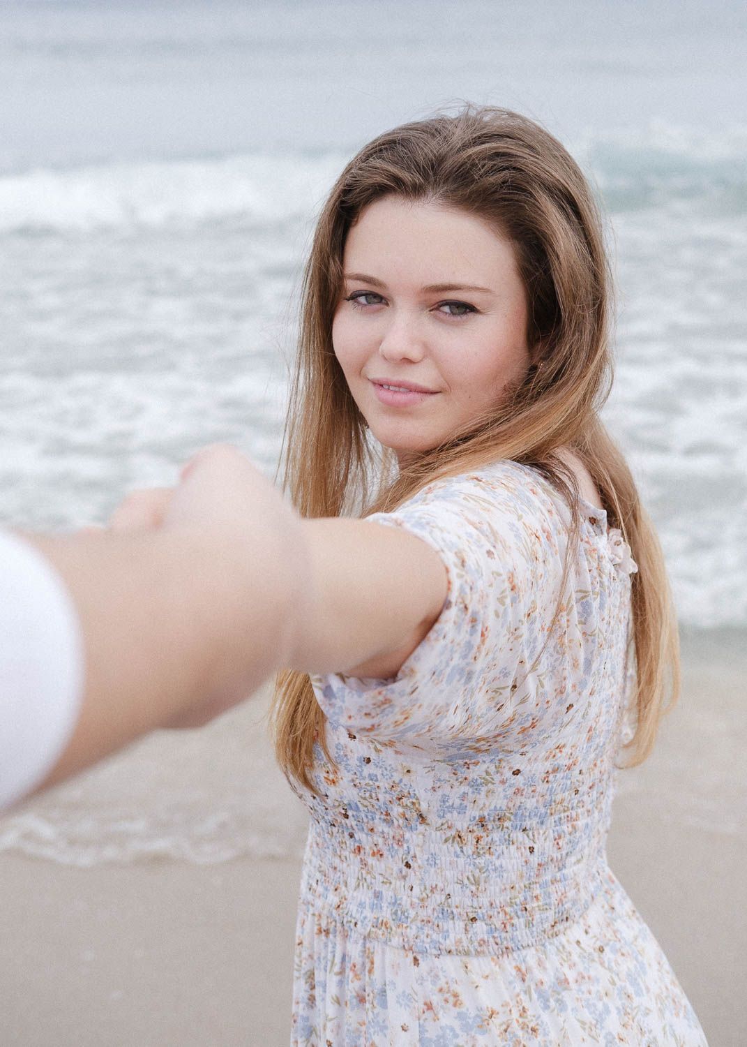 Lifestyle photo of a young woman and man at the beach.