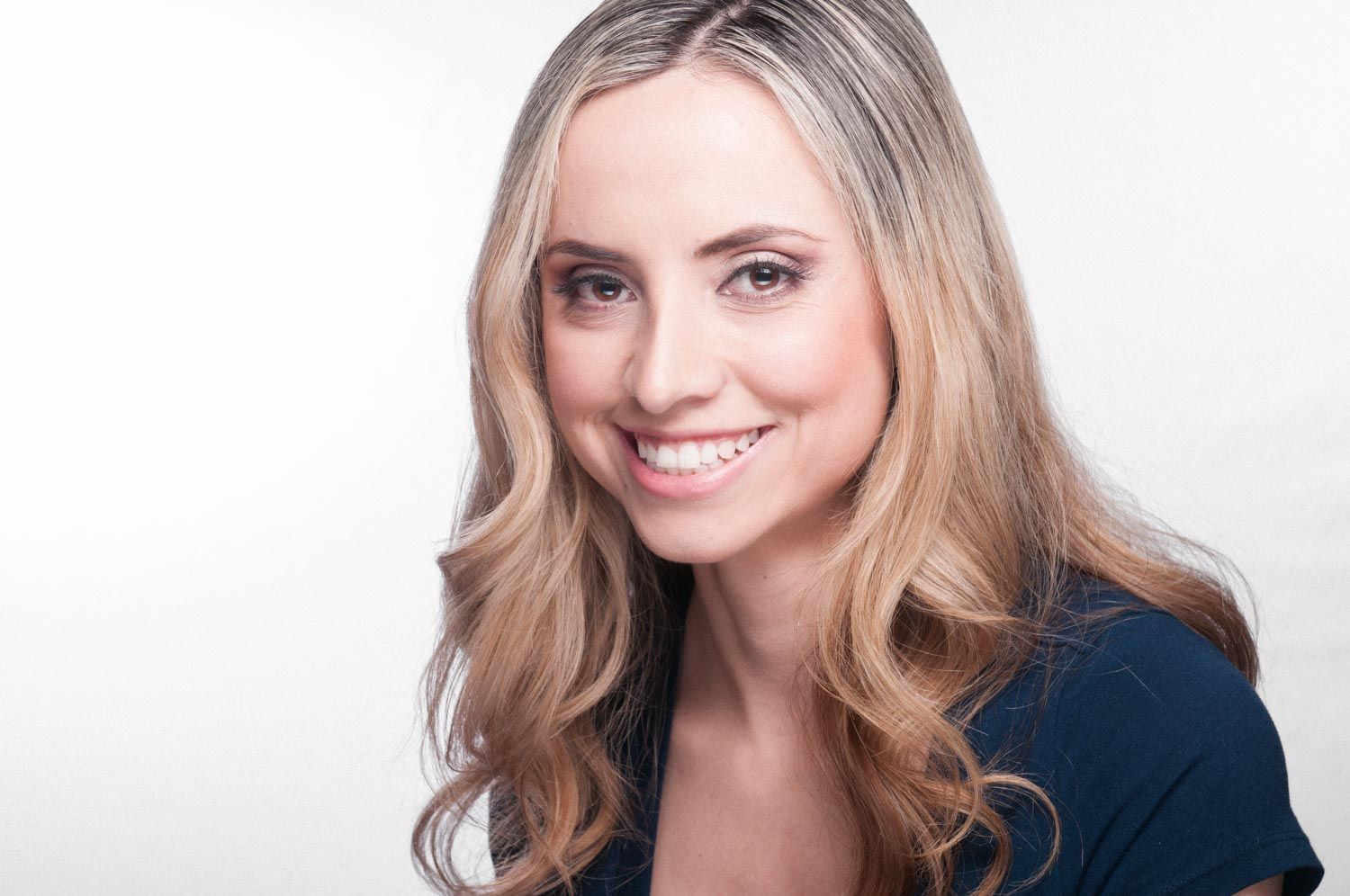 Stylized headshot of young woman with light hair in studio