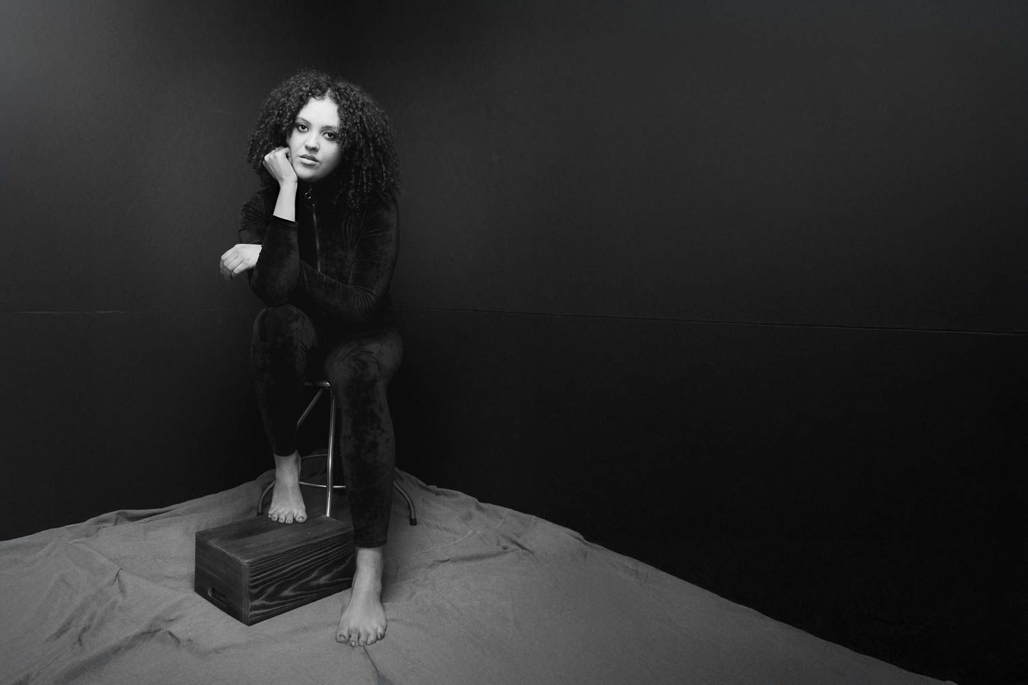 Creative and moody black and white portrait of young woman with dark hair in studio