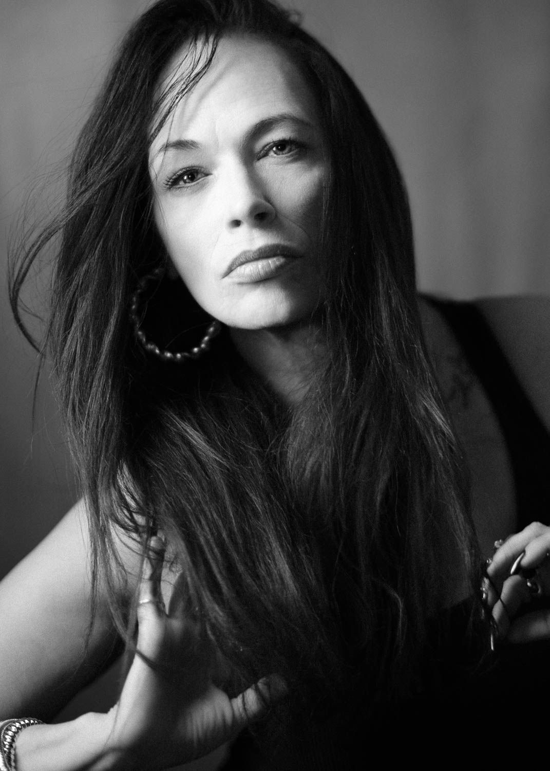 Creative and moody black and white portrait of young woman with dark hair in studio