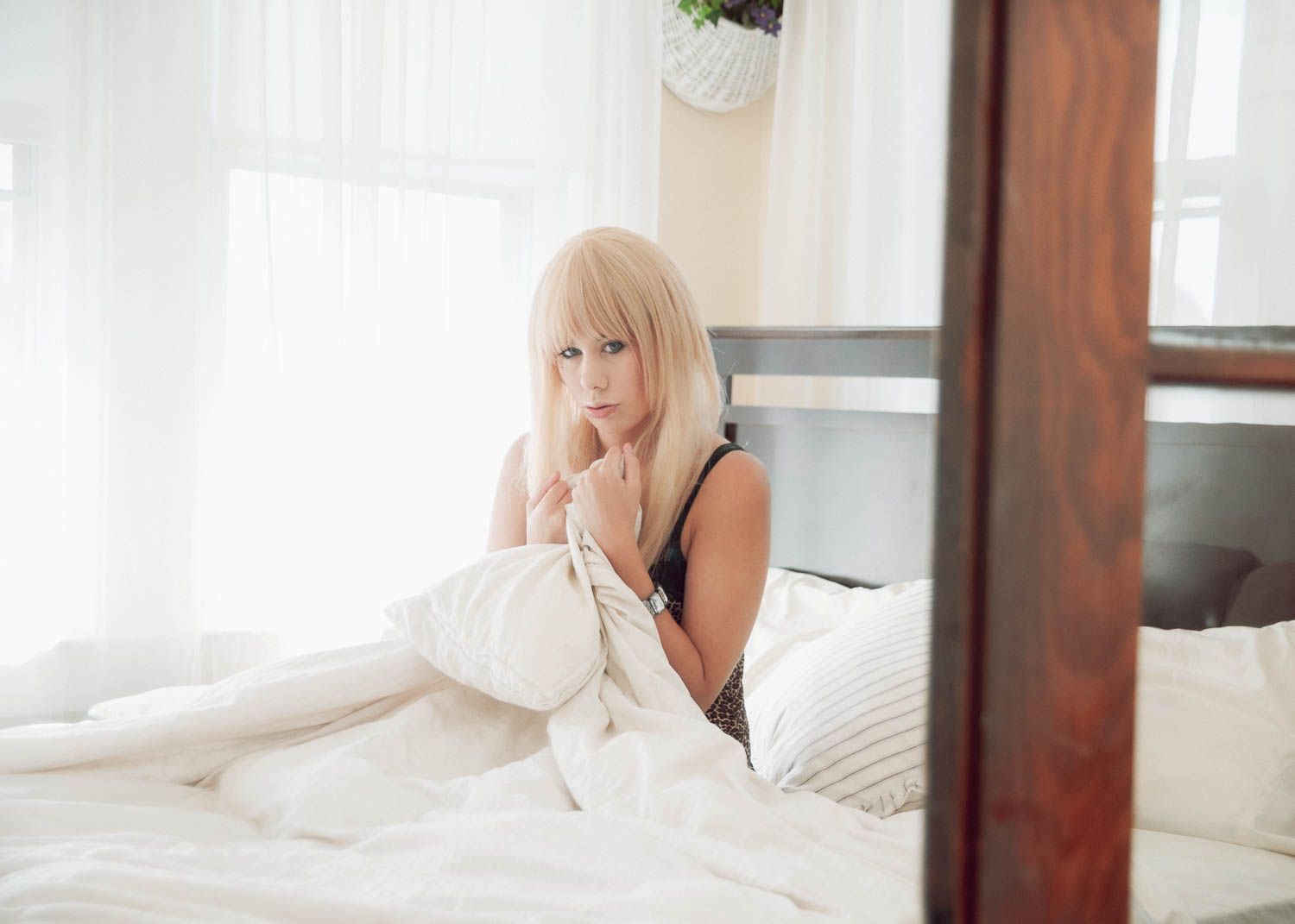 Portrait of woman with light hair in a bedroom