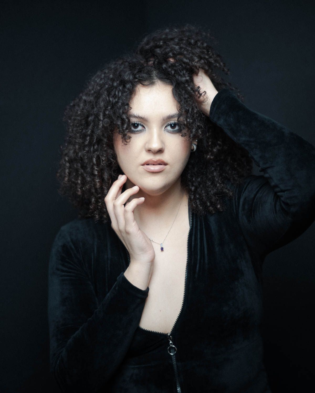 Portrait of young woman with dark hair in studio