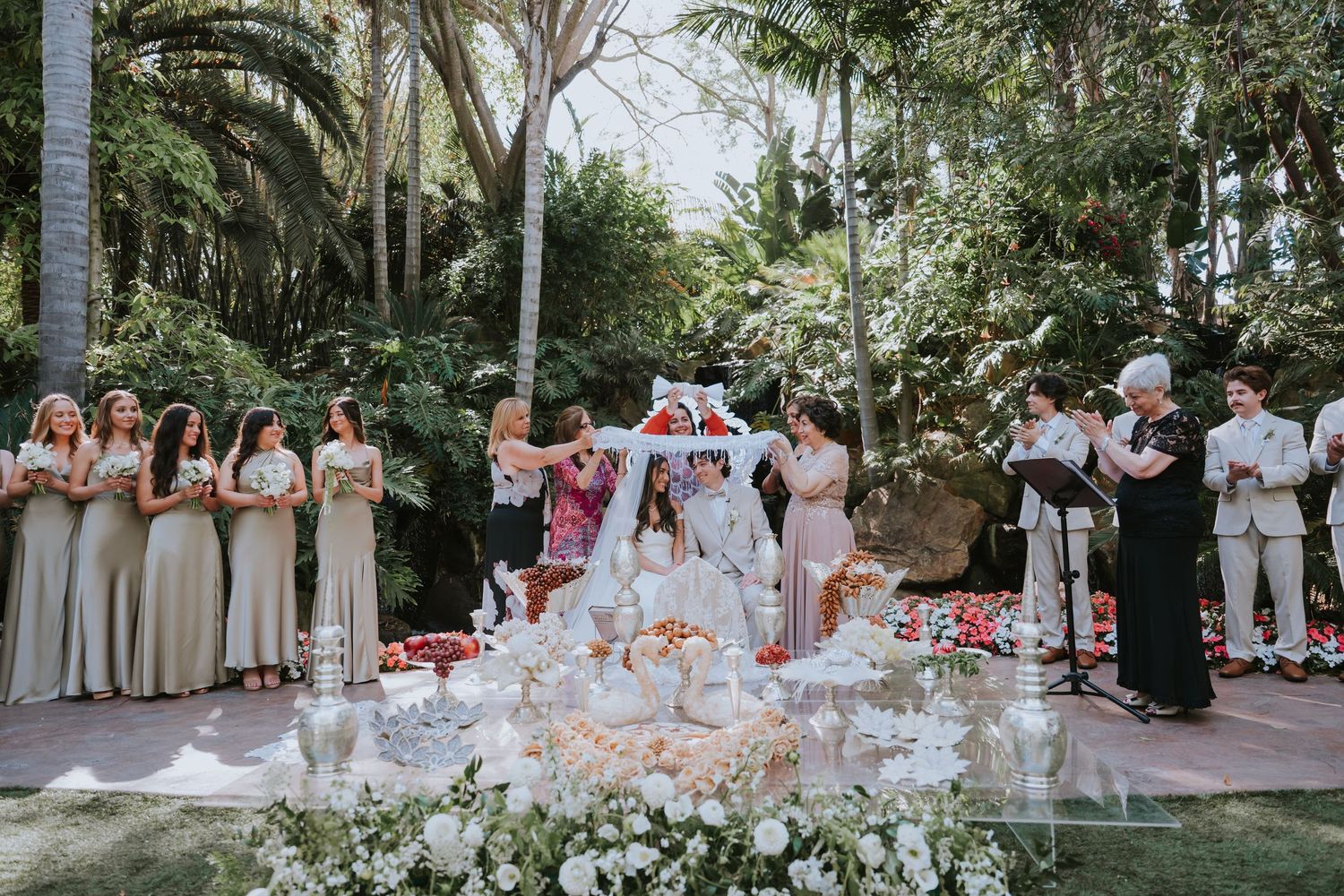 An outdoor wedding ceremony setup with white chairs and tropical palm trees in the background.
