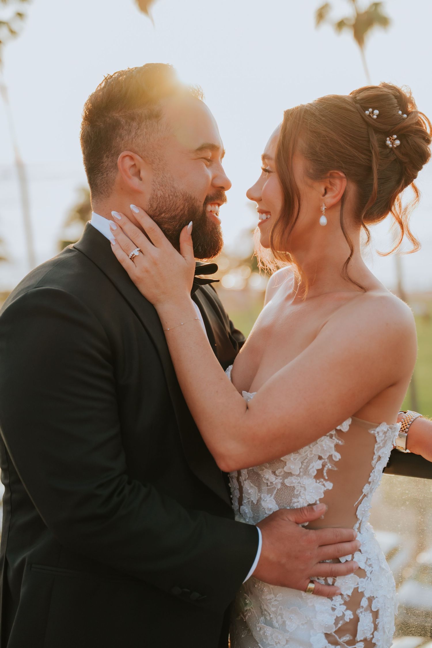 Intimate sunset wedding portrait with palm trees and golden light.