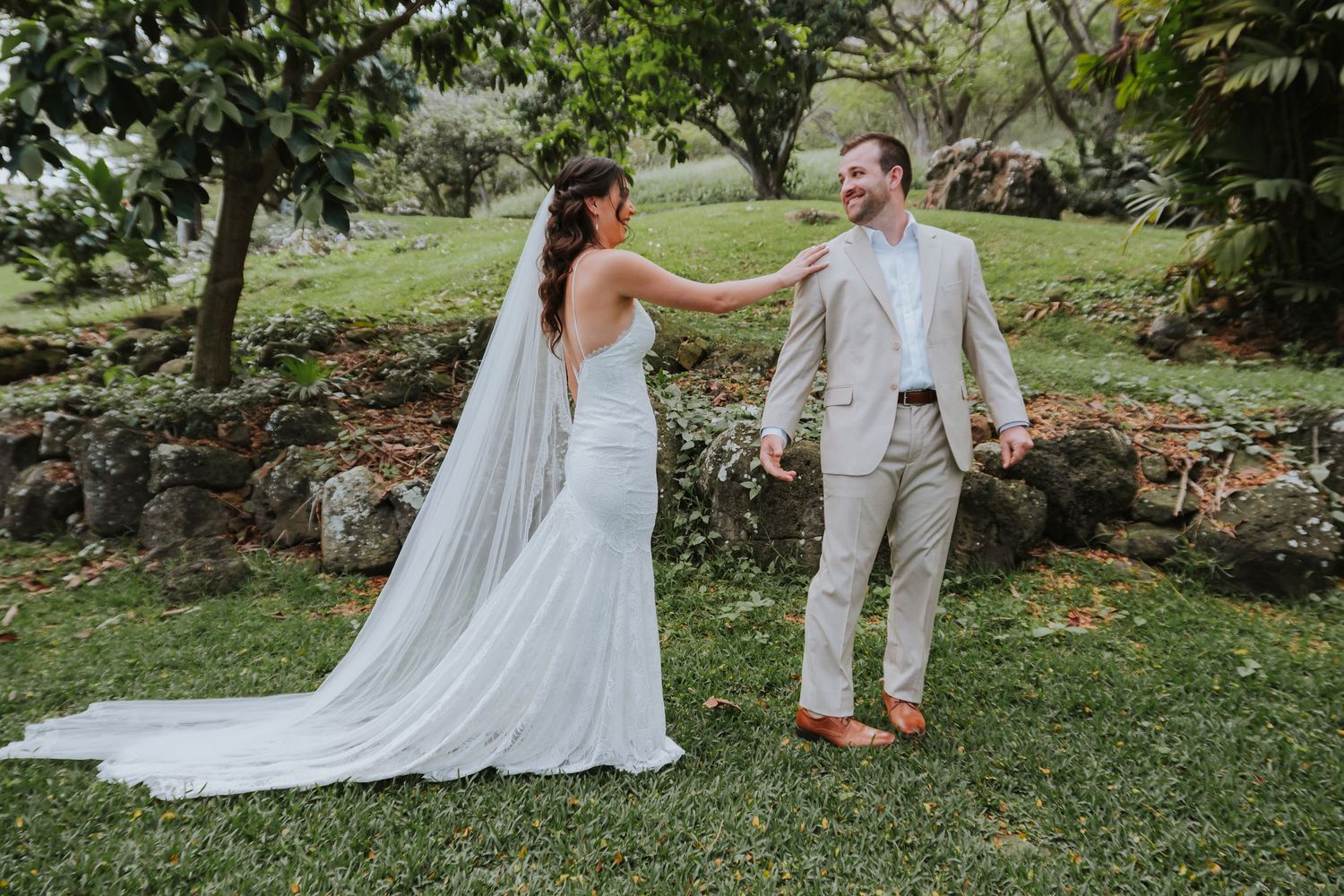 A romantic first look moment between a bride and groom in a lush garden setting.