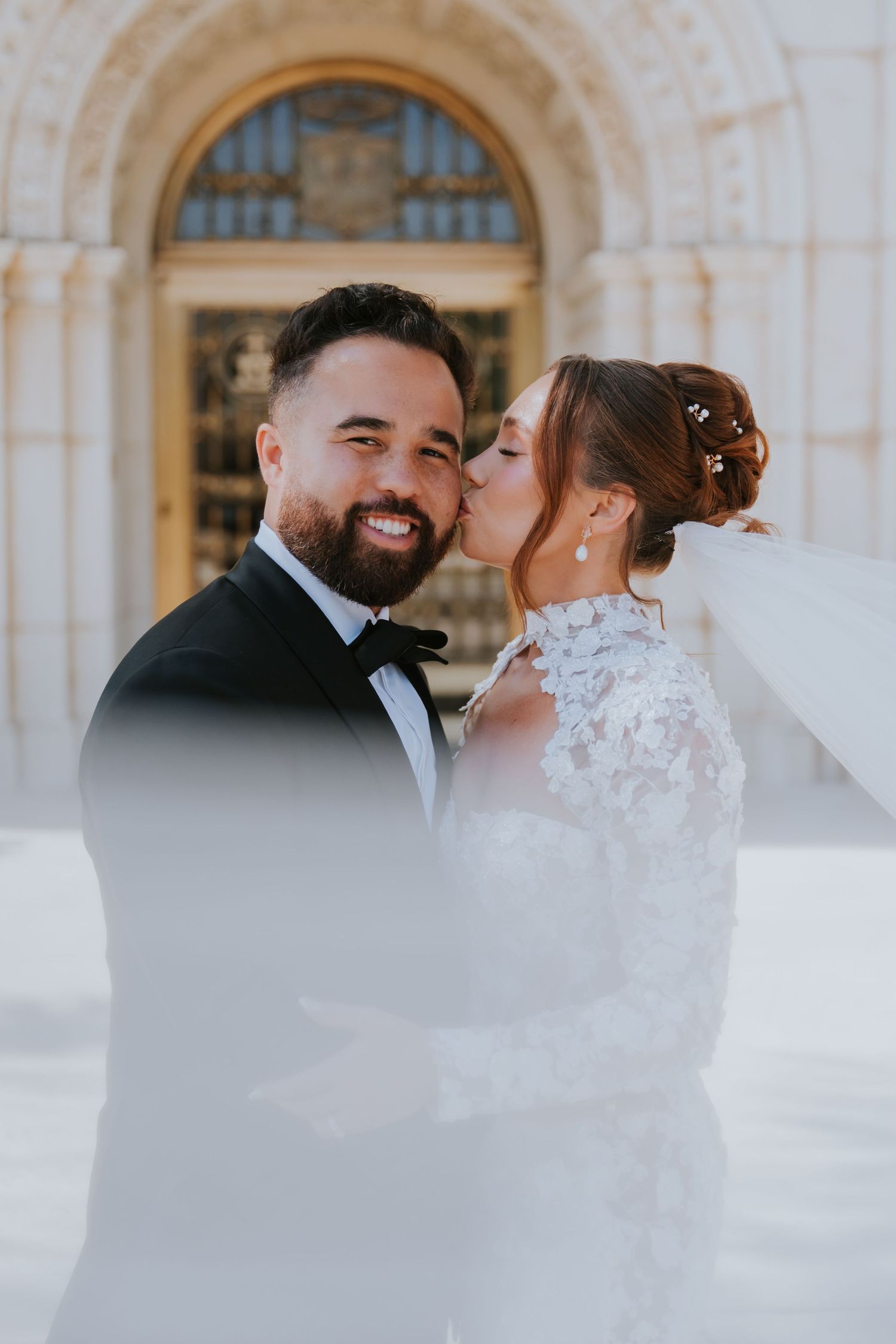 Intimate wedding portraits captured against white stone archways and columns.
