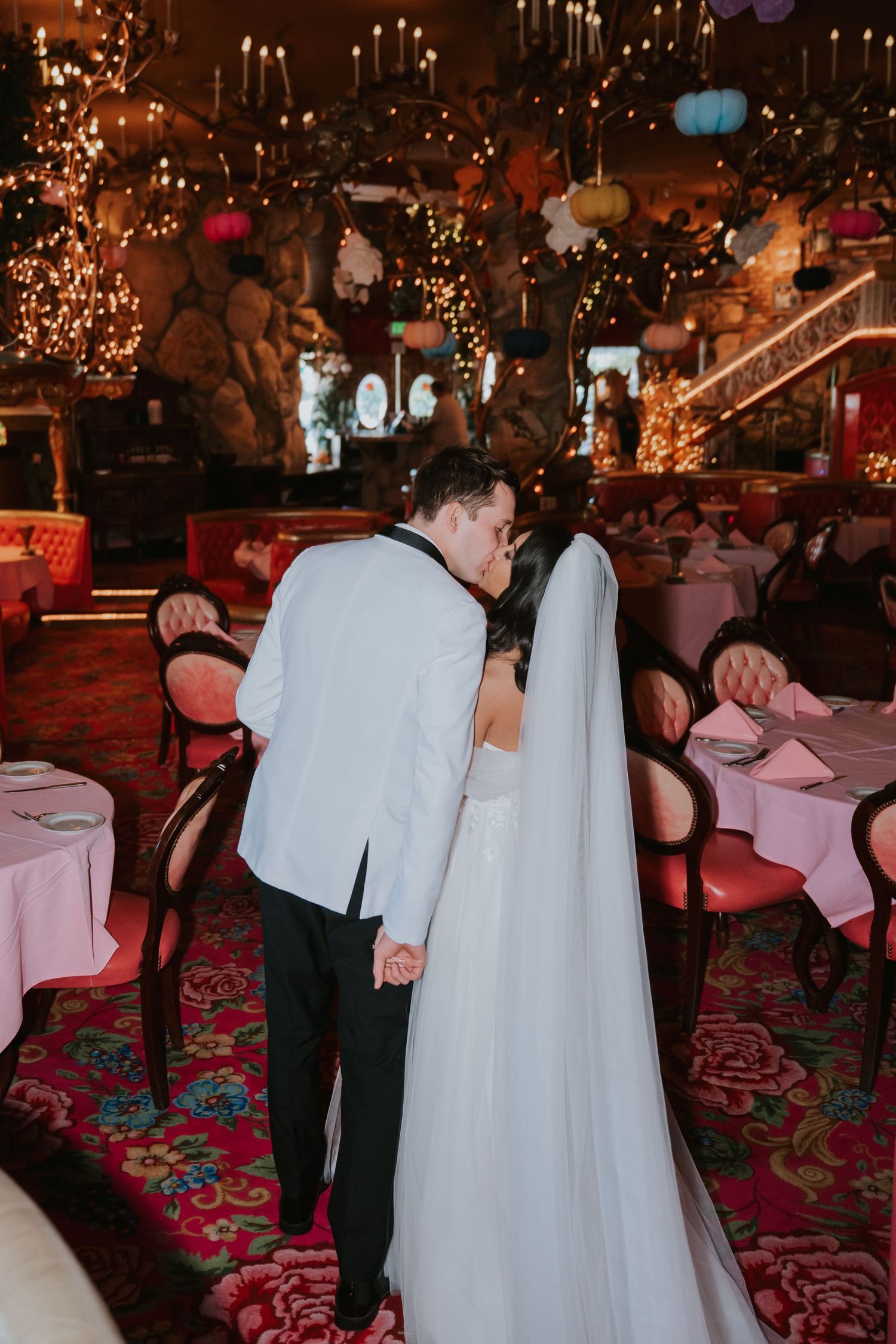 Wedding reception in an elegant candlelit venue with romantic lighting and ornate decor.
