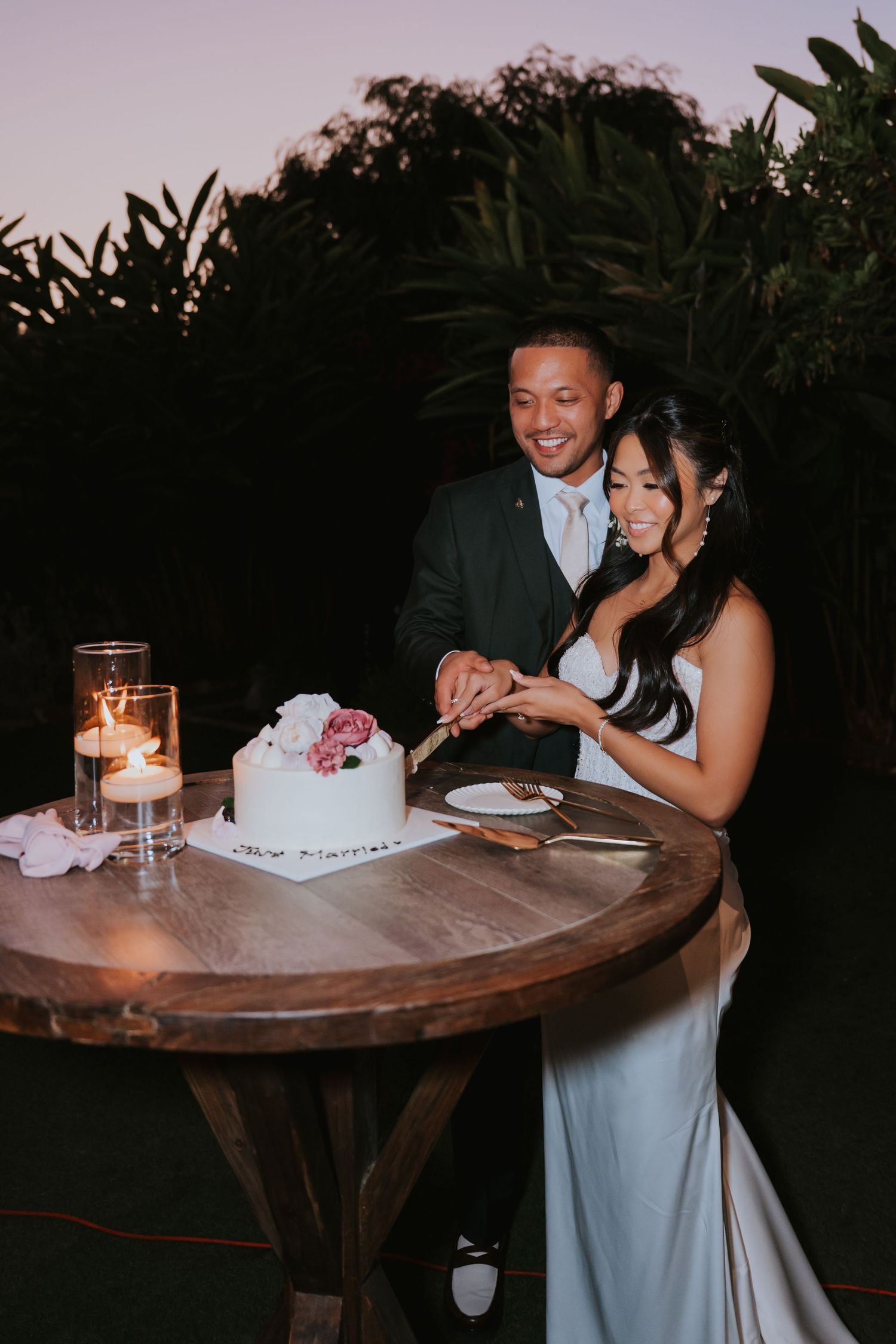 Romantic candlelit moment at a wedding reception with couple sharing dessert.
