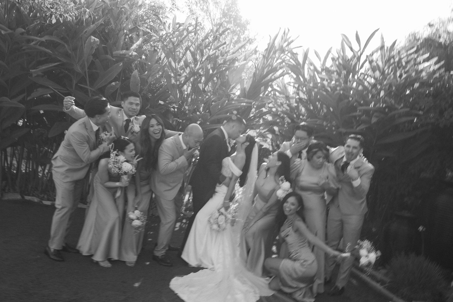 A sequence of black and white wedding celebration photos showing guests dancing and celebrating outdoors.