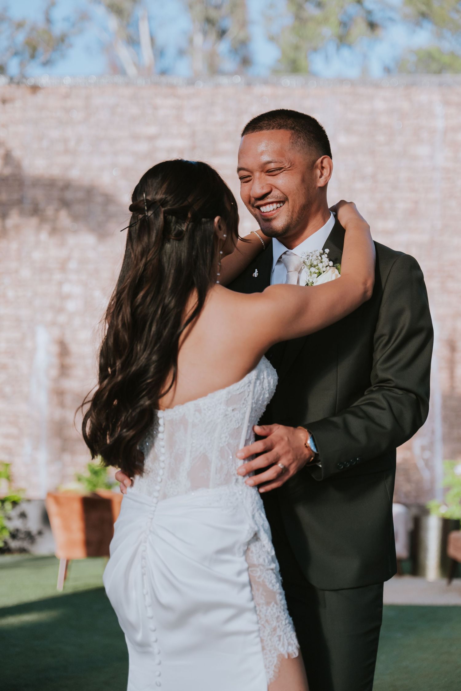 A couple shares a romantic dance moment outdoors during their wedding celebration.