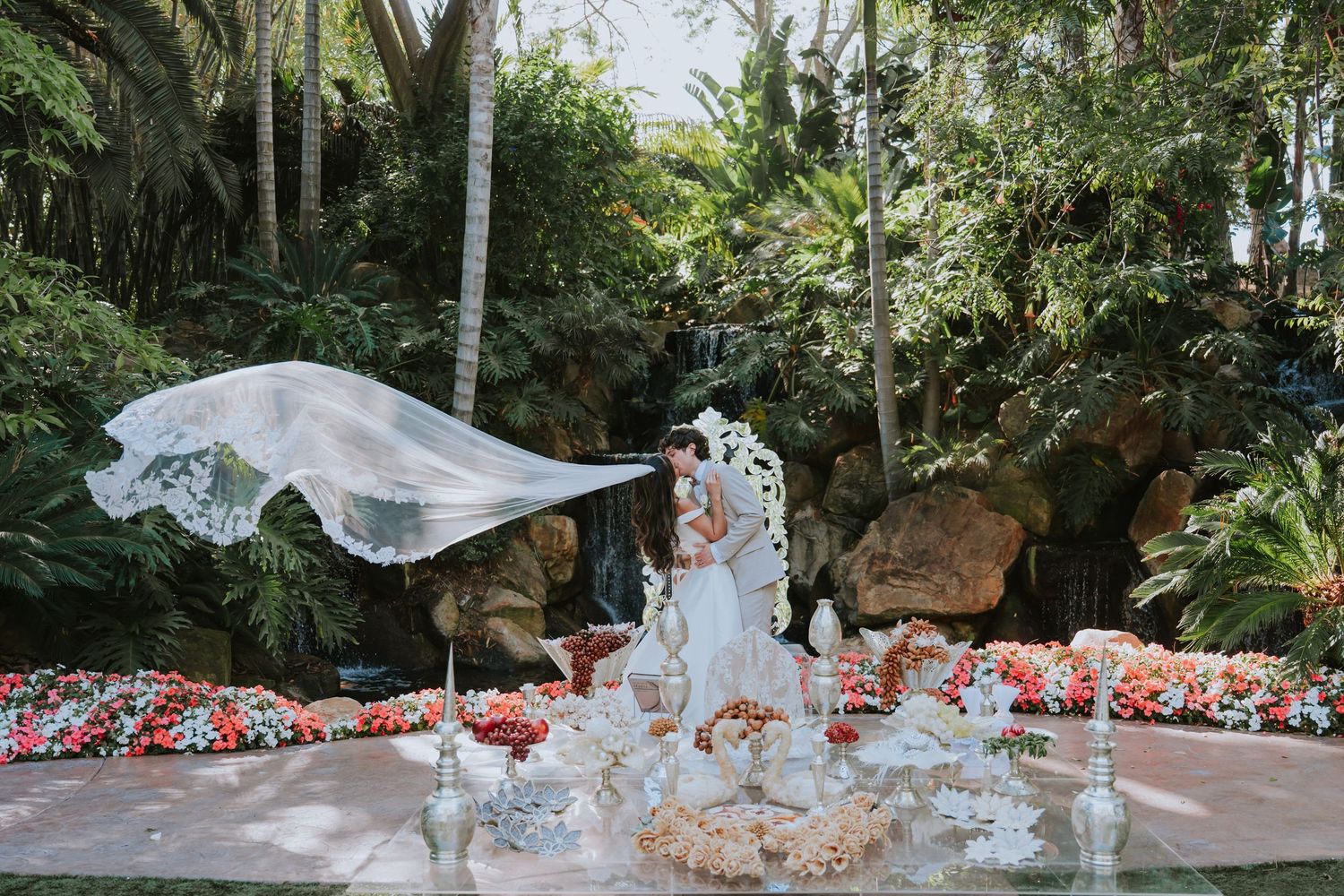 A romantic outdoor wedding ceremony with floral decorations and a garden backdrop.