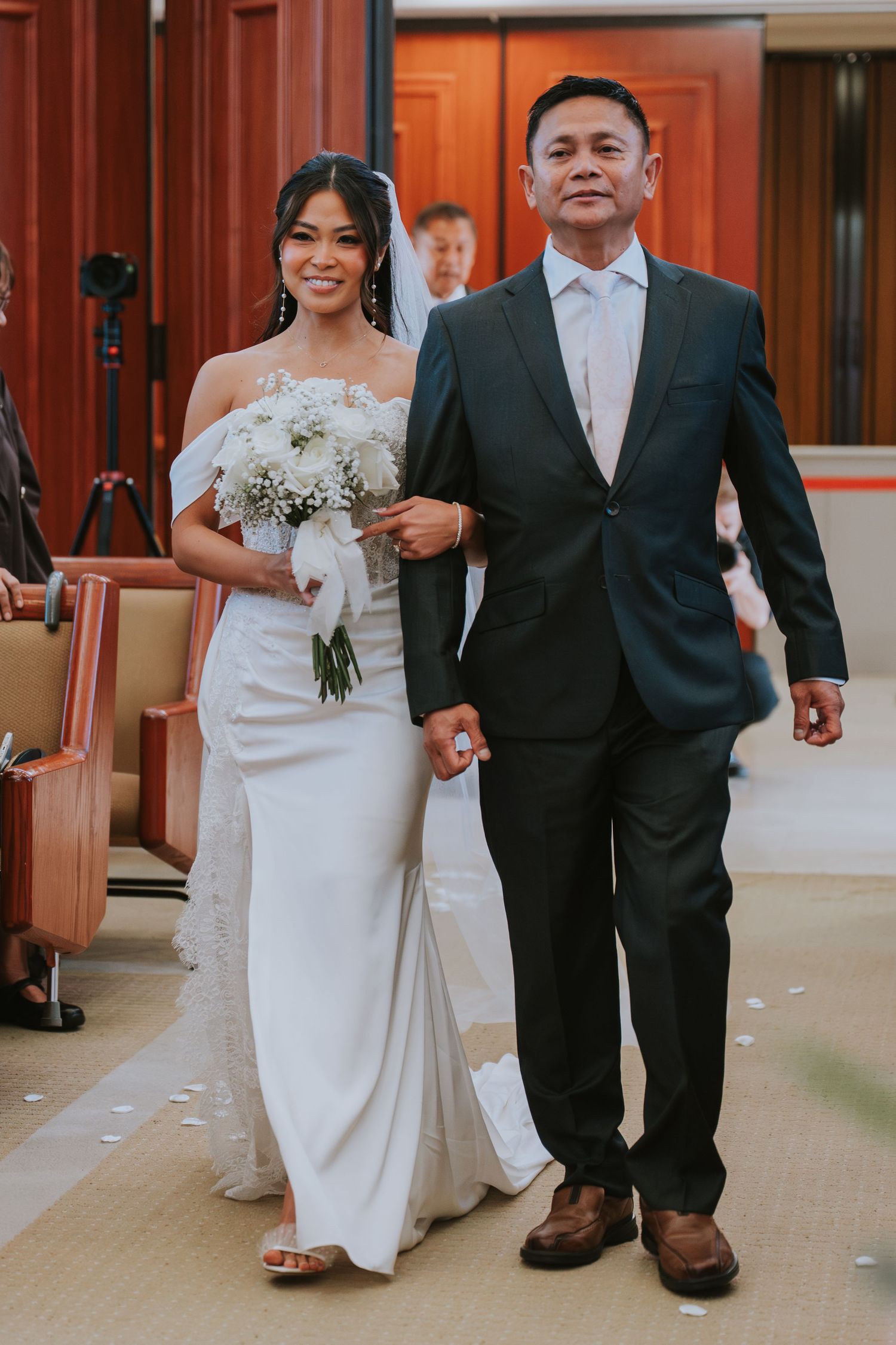 Wedding ceremony sequence showing couple walking down hallway in elegant white dress and black suit.