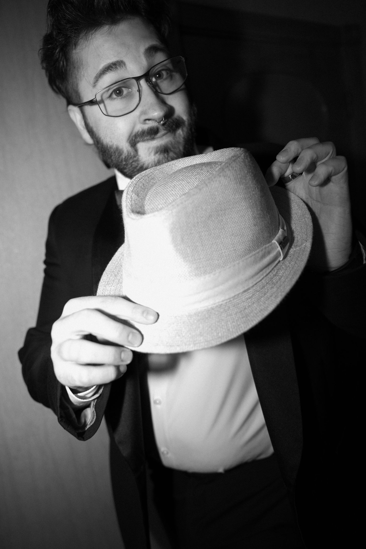 A series of black and white photos showing someone adjusting and positioning a white bucket hat.