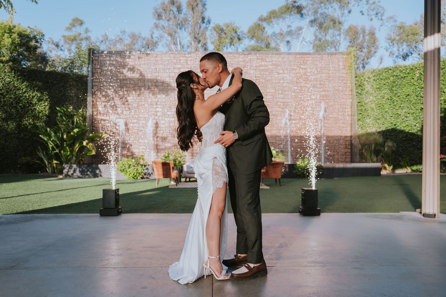 Couples dance together on an outdoor patio during a wedding celebration.