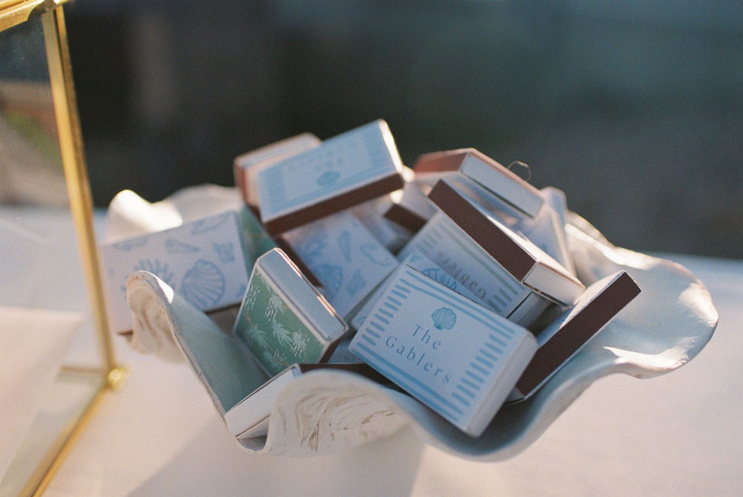 Elegant white dish filled with small branded chocolate favor boxes at a wedding or special event.
