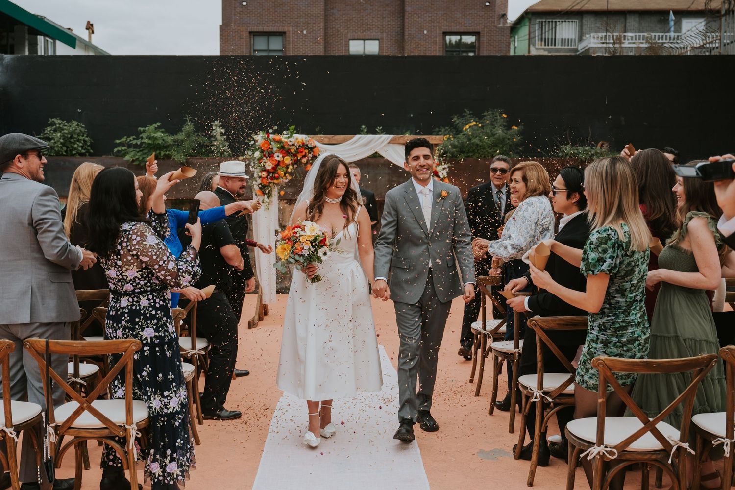 Wedding reception guests mingling and celebrating on an outdoor patio.
