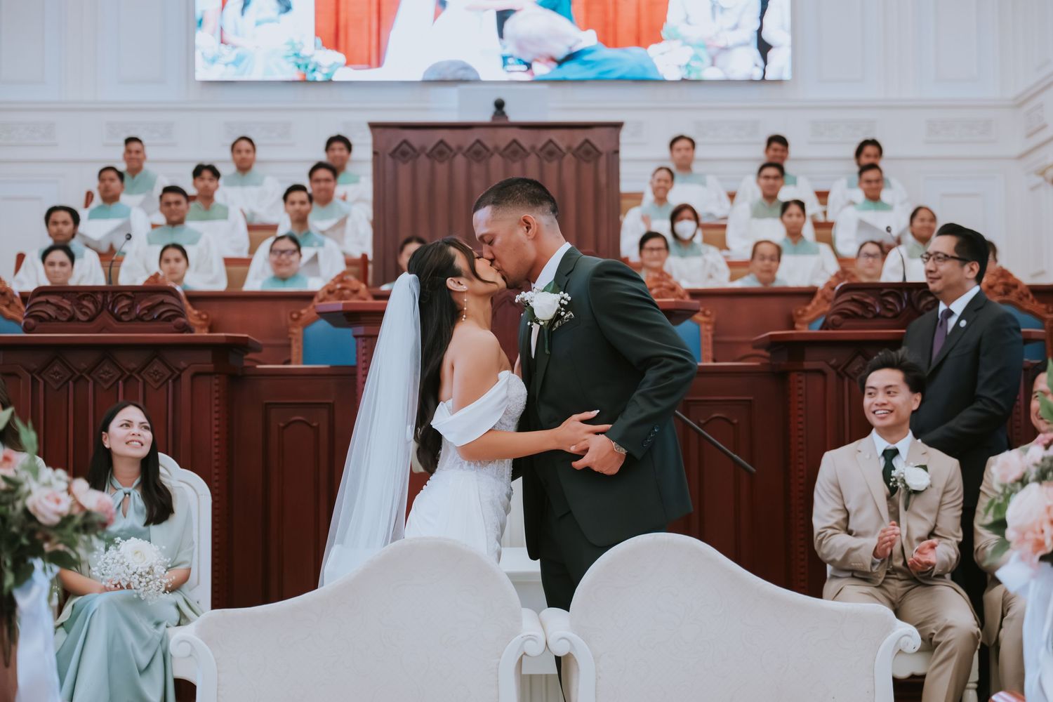 Wedding celebration scene showing guests and attendees gathered in an elegant church interior.