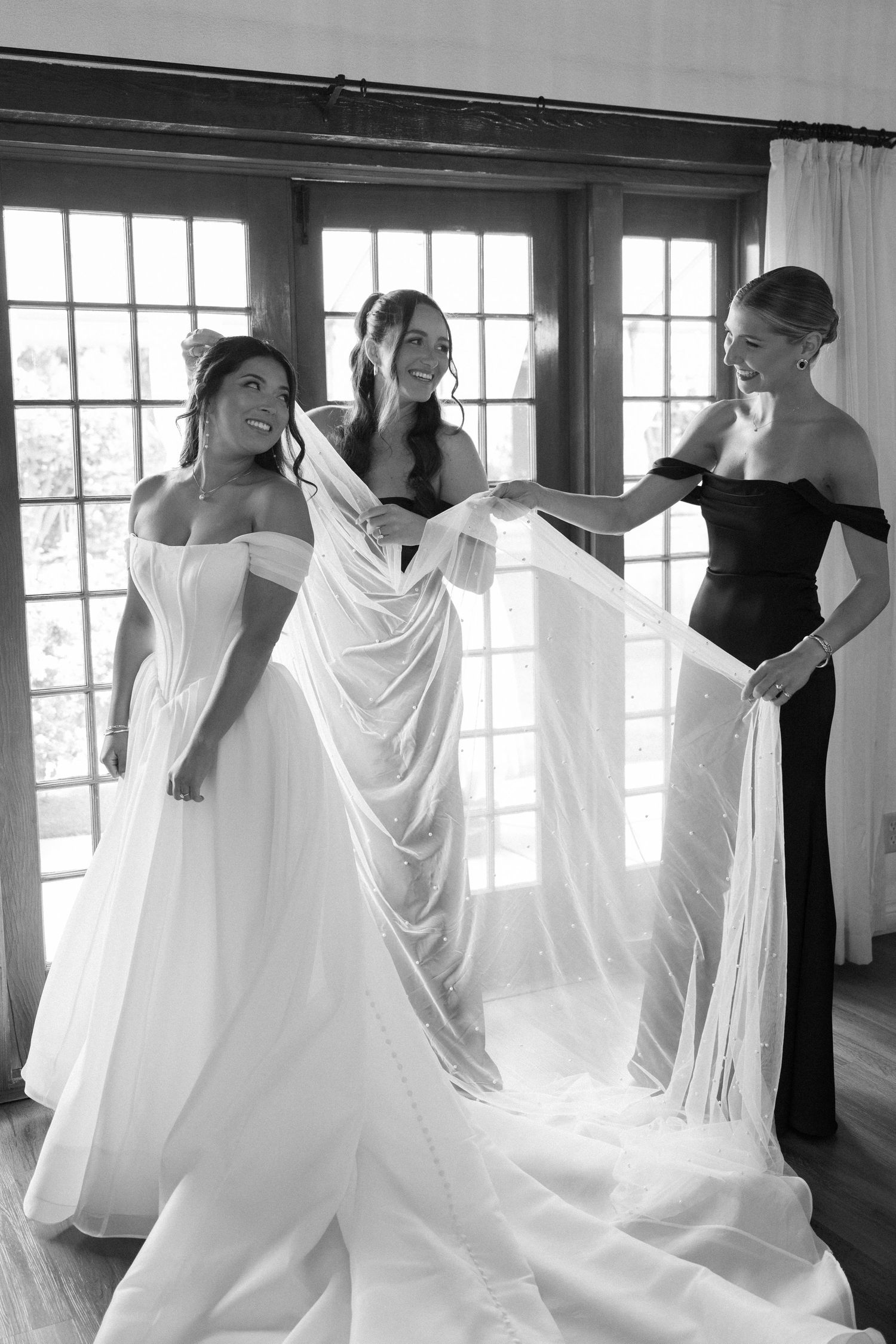 Black and white photo series showing flowing white dresses in an indoor setting with large windows.