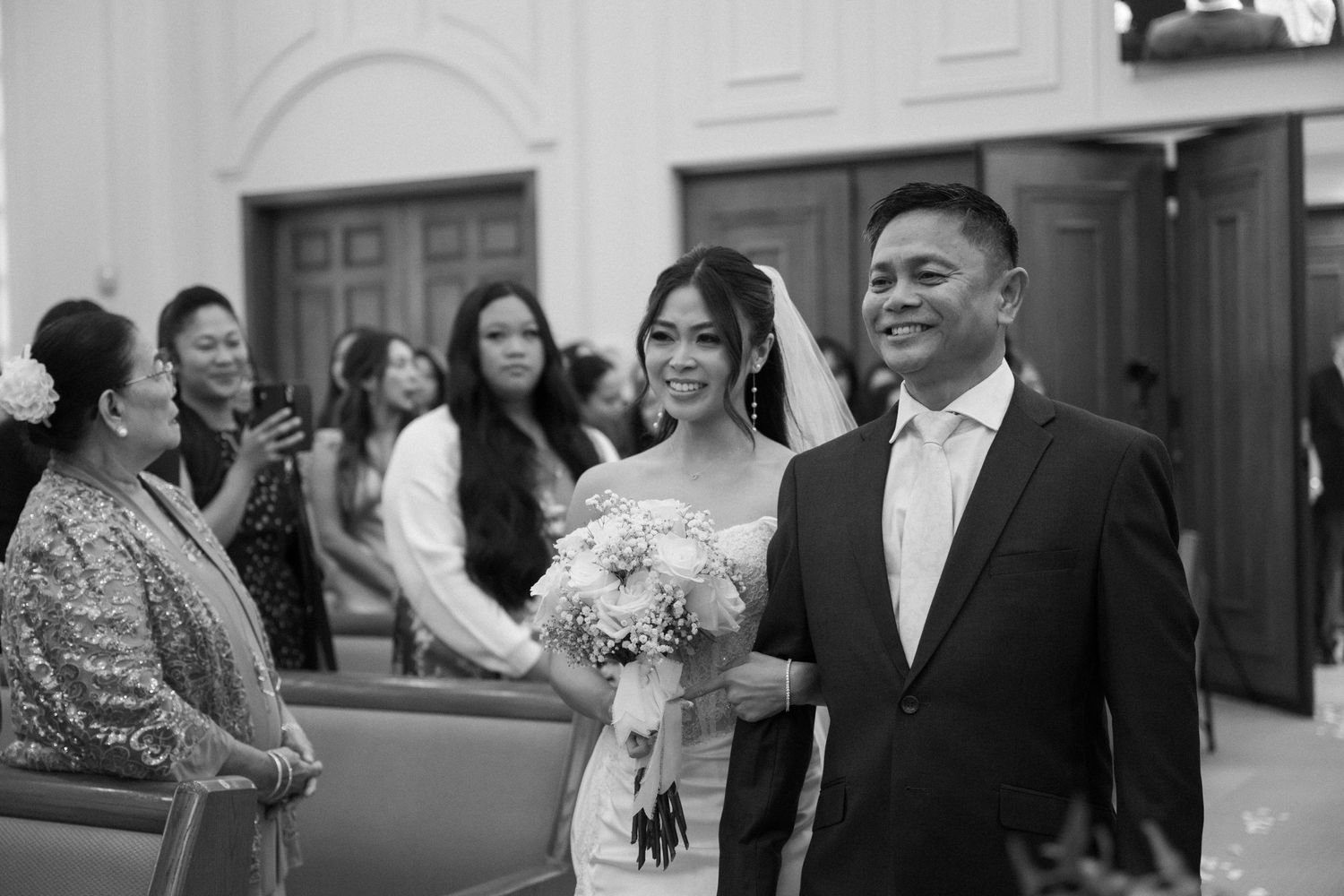 Wedding party members celebrate during a joyful reception moment in a banquet hall.
