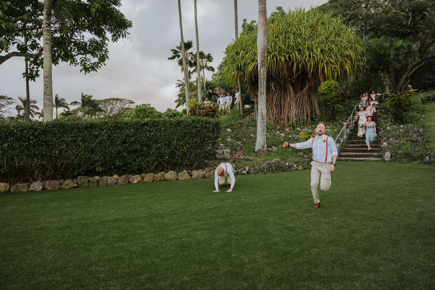Guests enjoying outdoor celebration on landscaped lawn with palm trees.