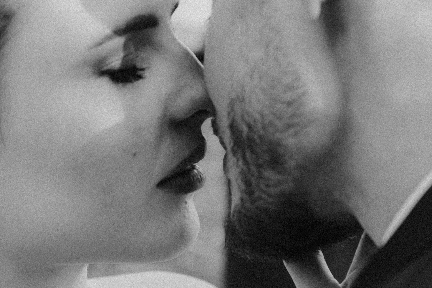Close up black and white portrait of a tender romantic moment between two people about to kiss.