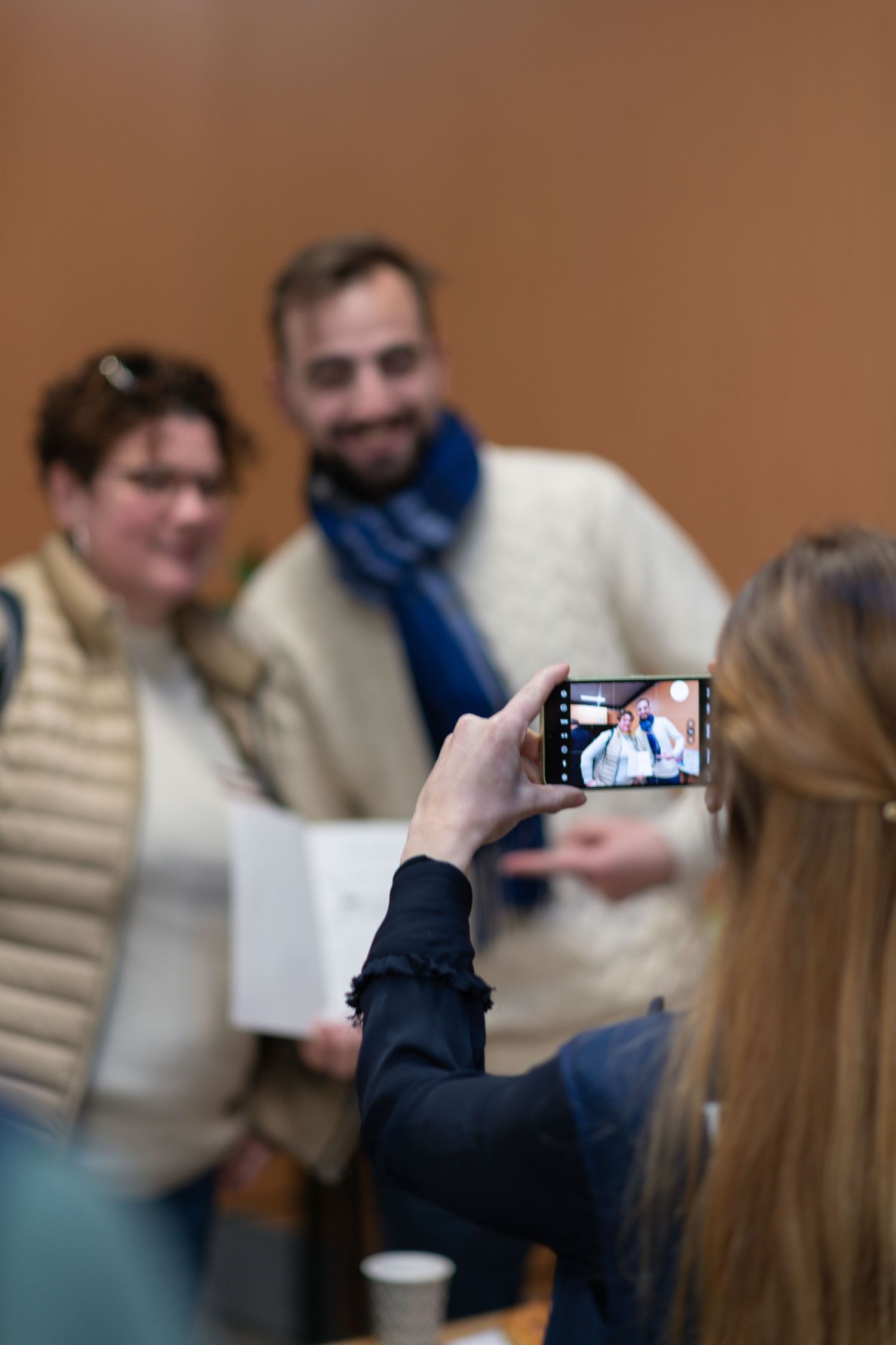 A series of blurry photos showing someone taking pictures with a phone camera at an indoor gathering.