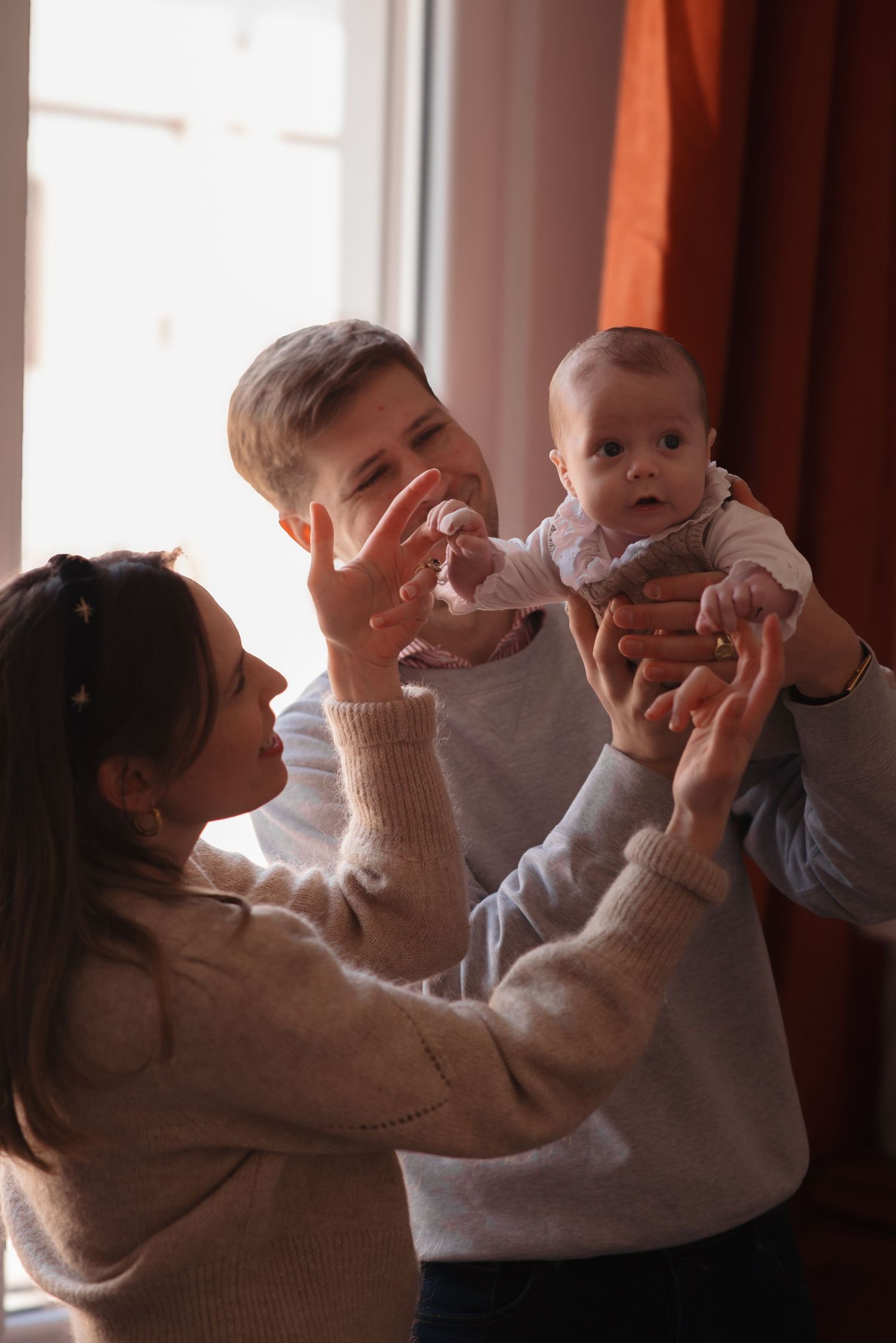 Family sharing tender moment with baby in cozy home setting.