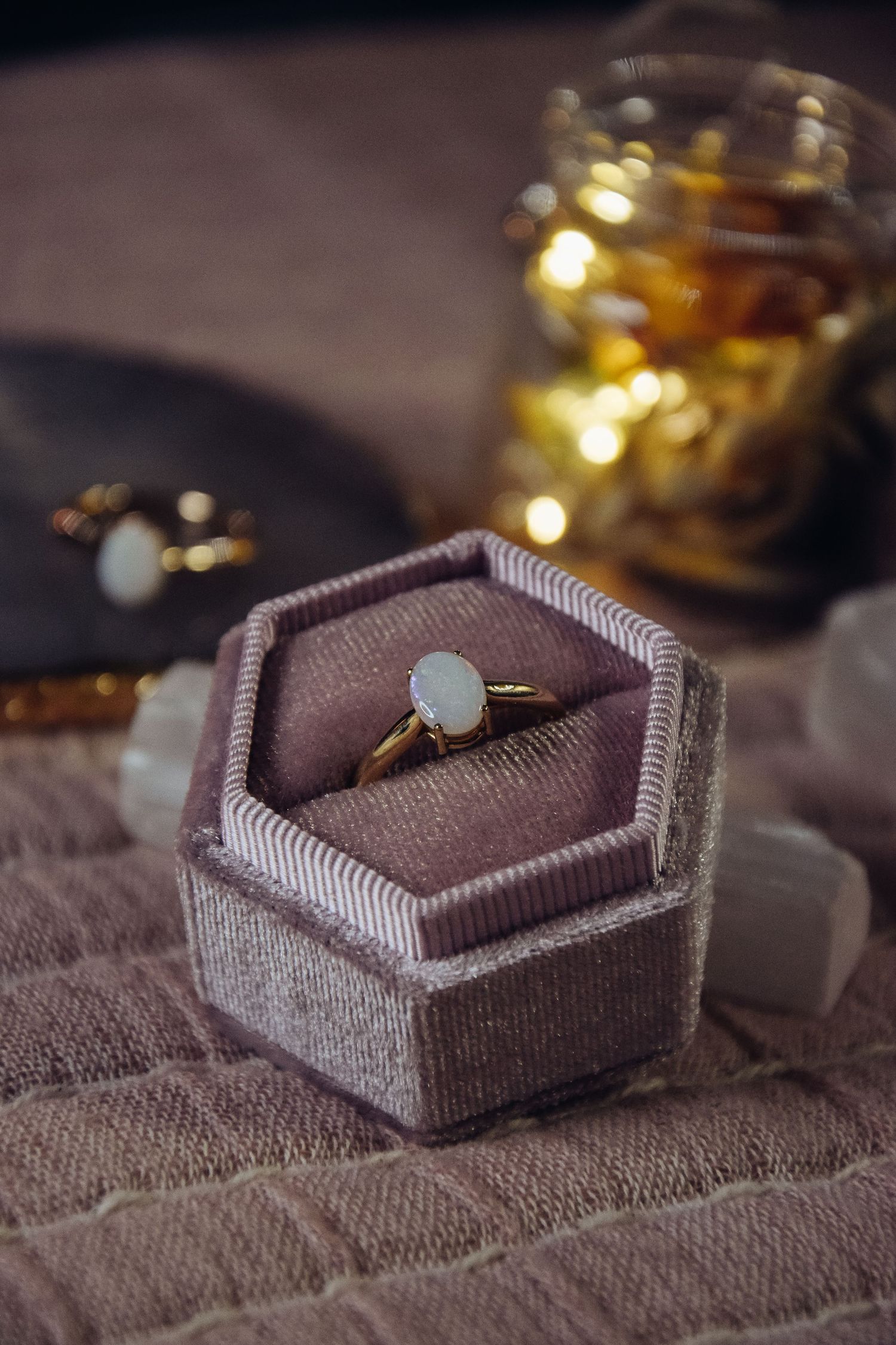 Opal engagement ring displayed in a grey velvet hexagonal ring box.